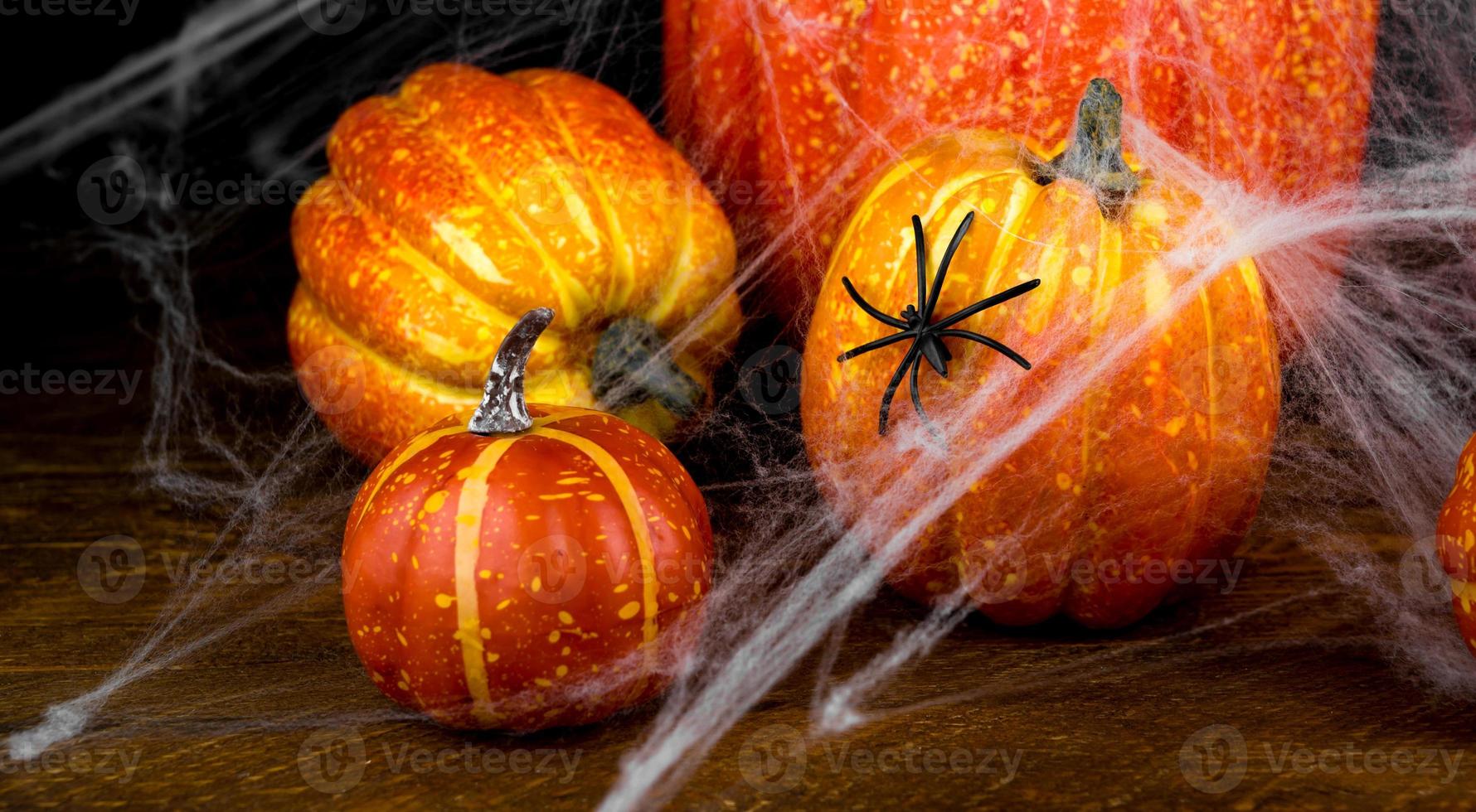 Mysterious halloween background with pumpkins covered in web with spiders.Selective focus.October 31 concept photo