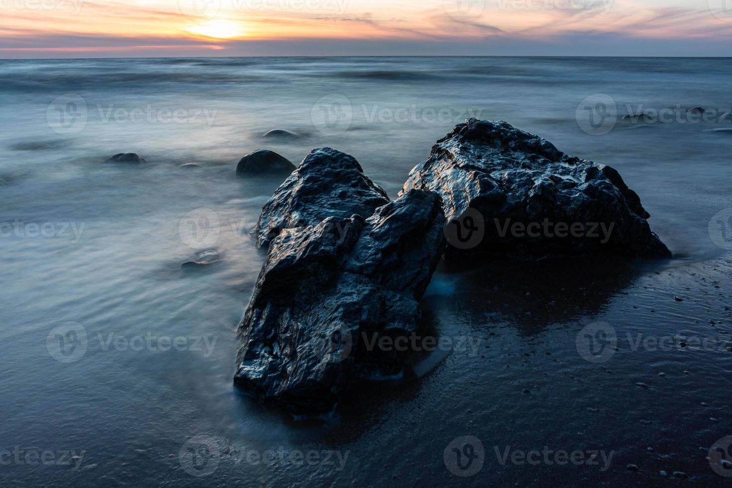 piedras en la costa del mar Báltico al atardecer foto