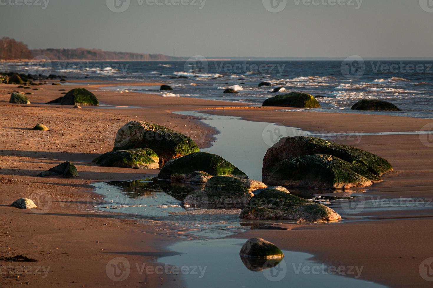 piedras en la costa del mar Báltico al atardecer foto