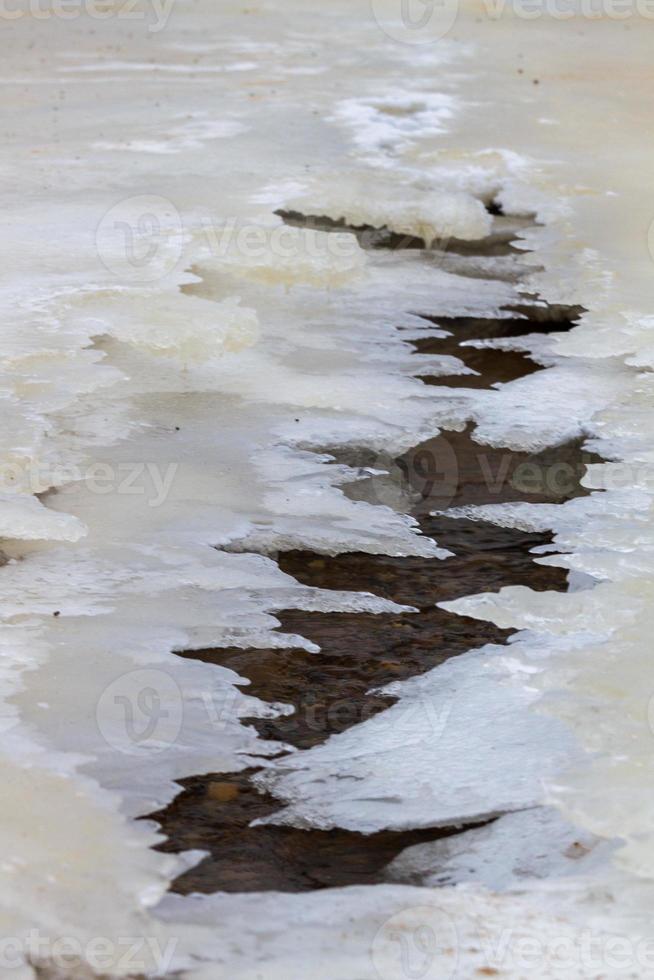 costa del mar báltico con guijarros y hielo al atardecer foto