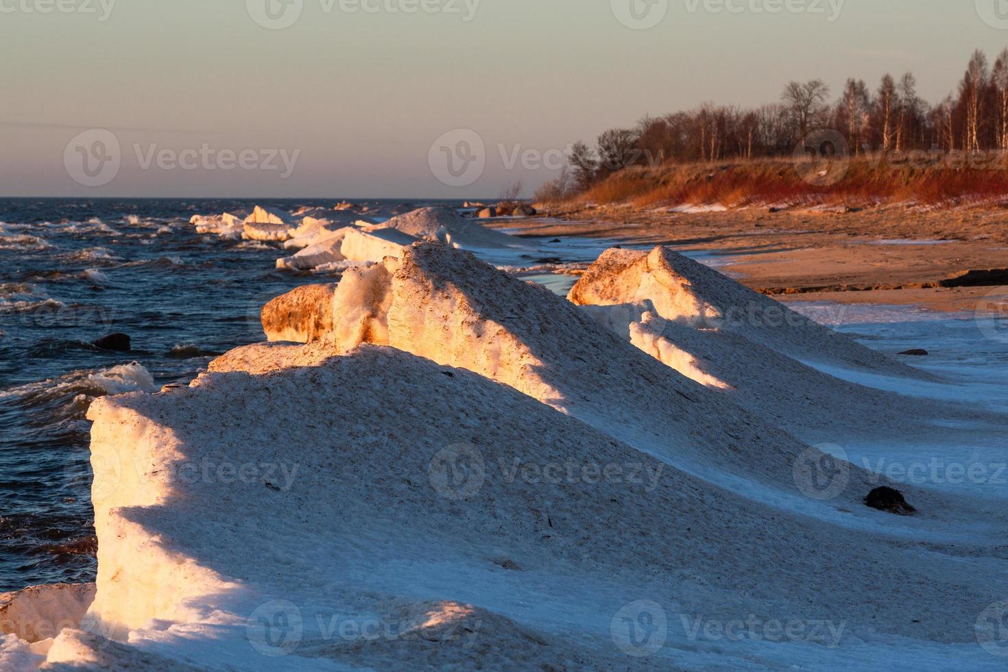 Baltic Sea Coast With Pebbles And Ice at Sunset photo