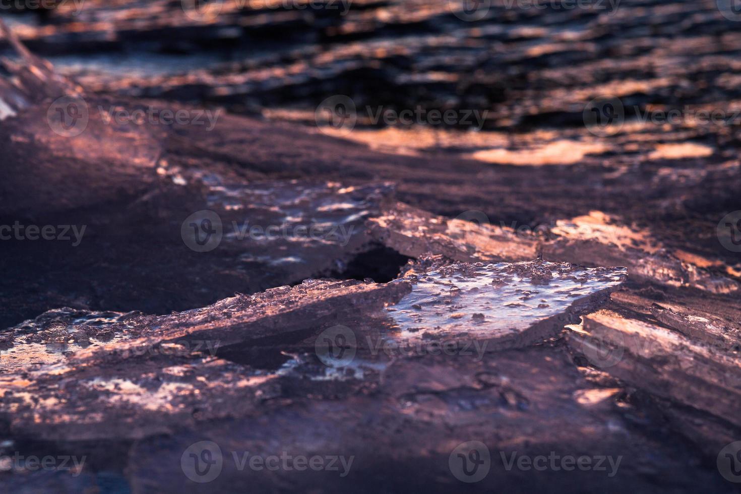 costa del mar báltico con guijarros y hielo al atardecer foto