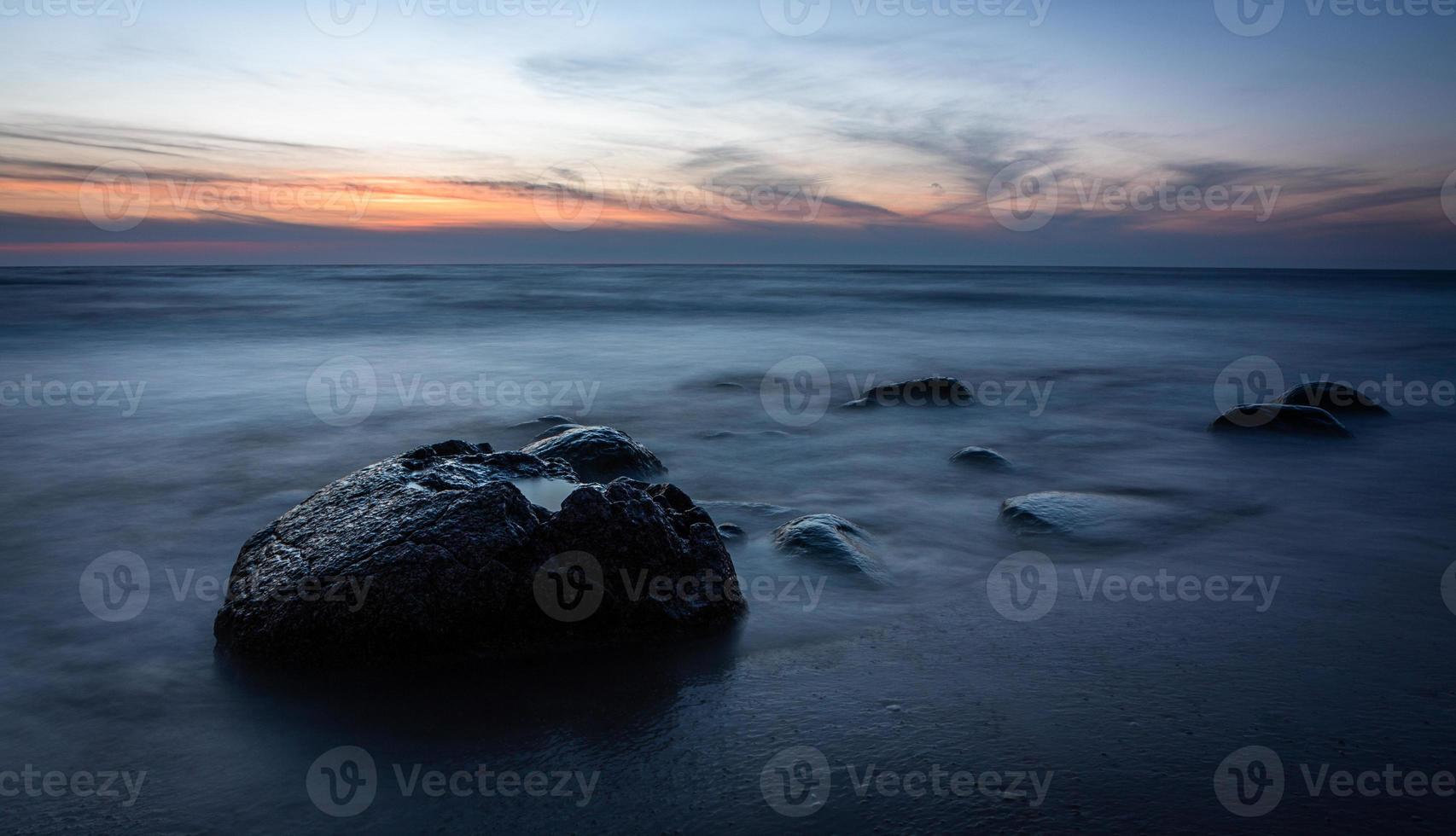 piedras en la costa del mar Báltico al atardecer foto