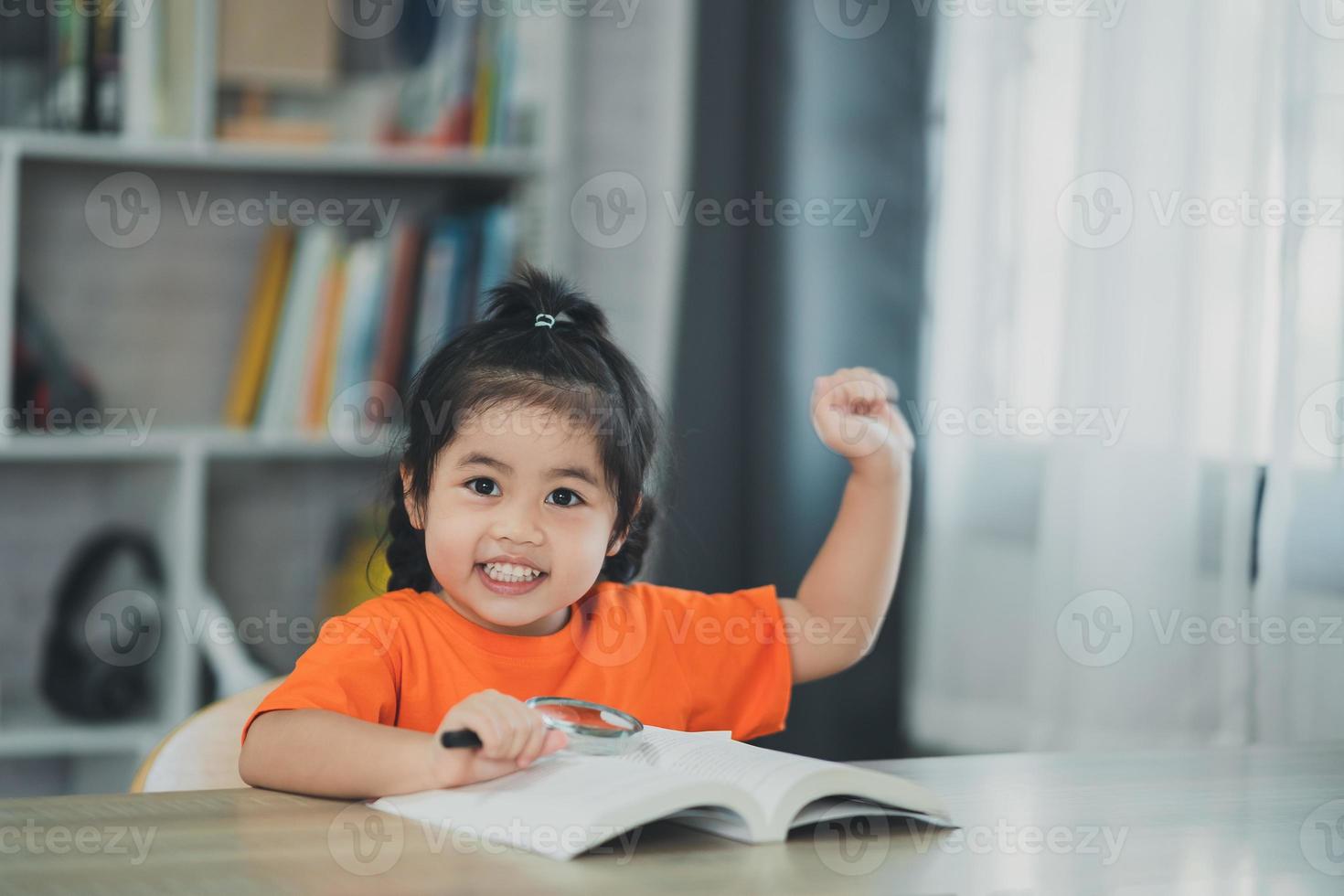 Asian baby kid girl holding magnifying glass and raise your hand reading  book education, children and school concept - happy smiling student girl learning  studying. Education development concept. 14995490 Stock Photo at Vecteezy