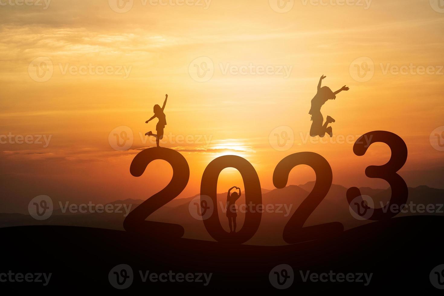 mujer salta feliz concepto de año nuevo 2023, silueta de mujer saltando sobre el acantilado de la barrera y éxito con un hermoso fondo de puesta de sol. feliz año nuevo 2023 uso para banner web y publicidad. foto