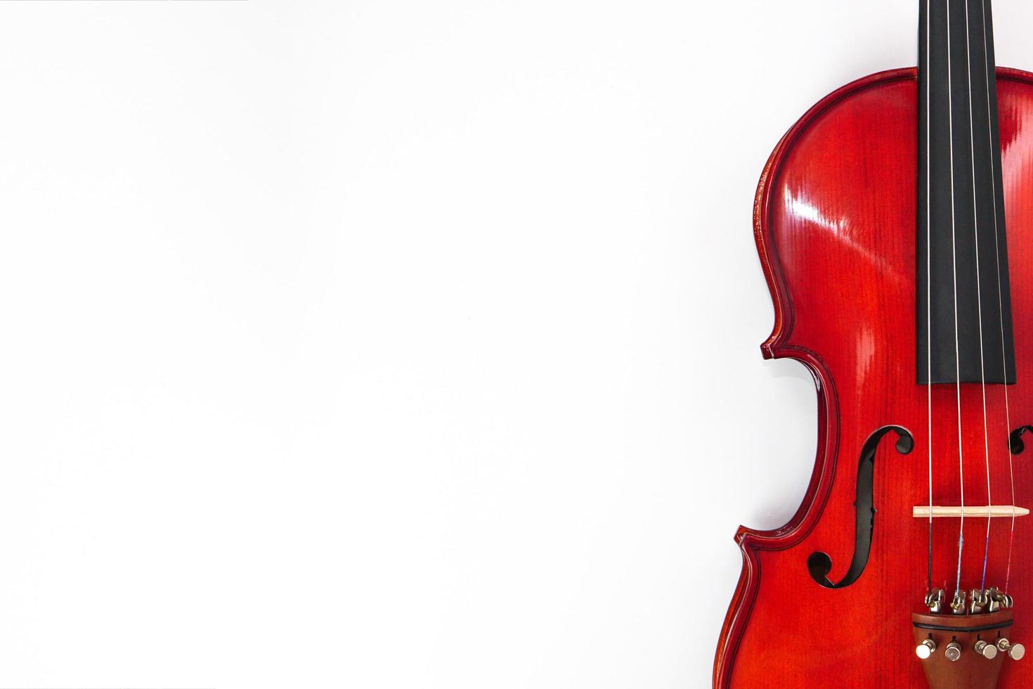 Violin leaning against a blank wall white background with copy space. Instrument and musical concept. photo