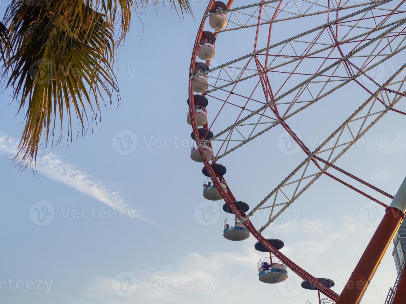 Ferris wheel against the sky. Amusement park by the sea. Rest zone. Round mechanism. Height lovers. photo