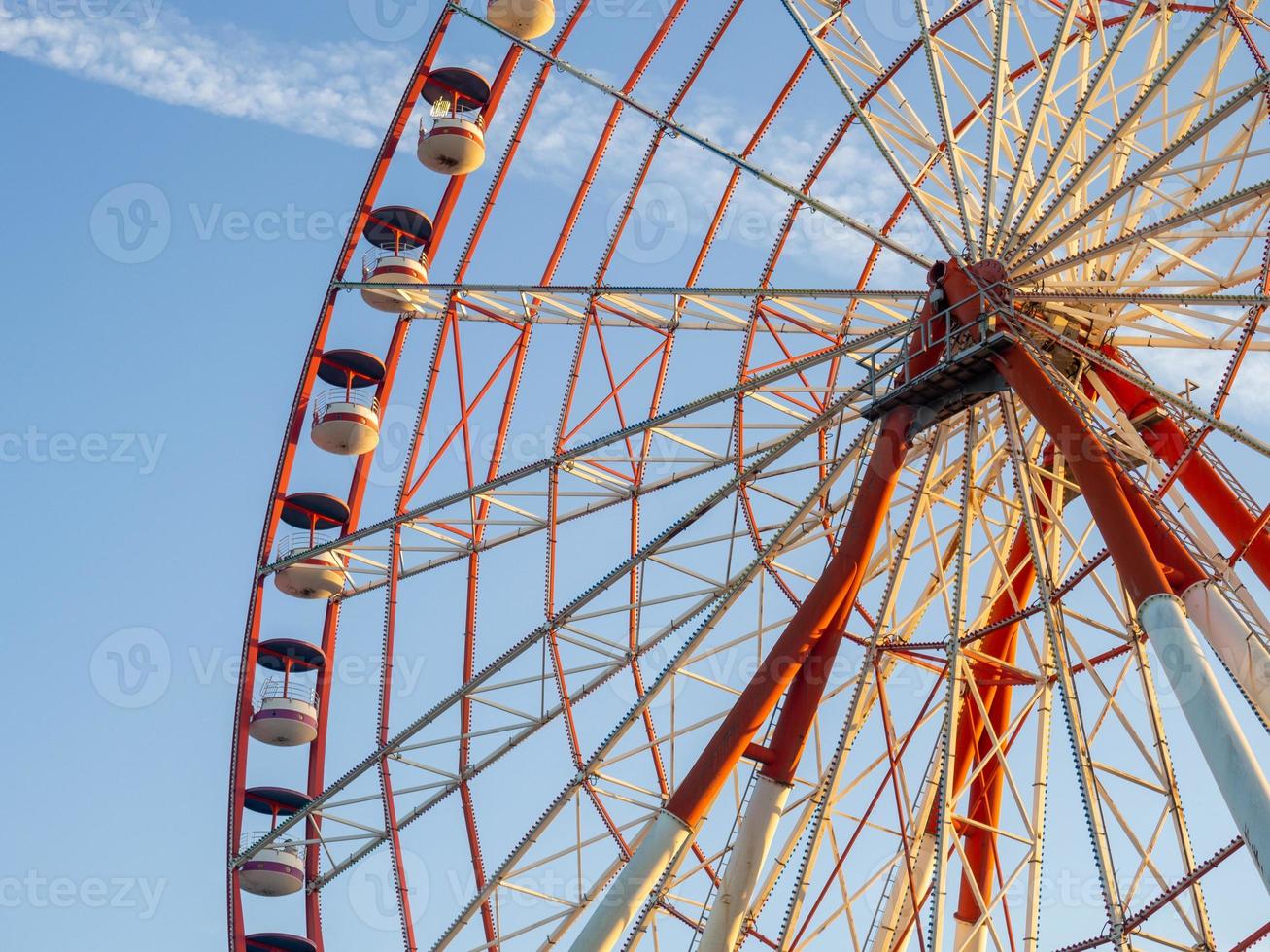 Ferris wheel against the sky. Amusement park by the sea. Rest zone. Round mechanism. Height lovers. photo