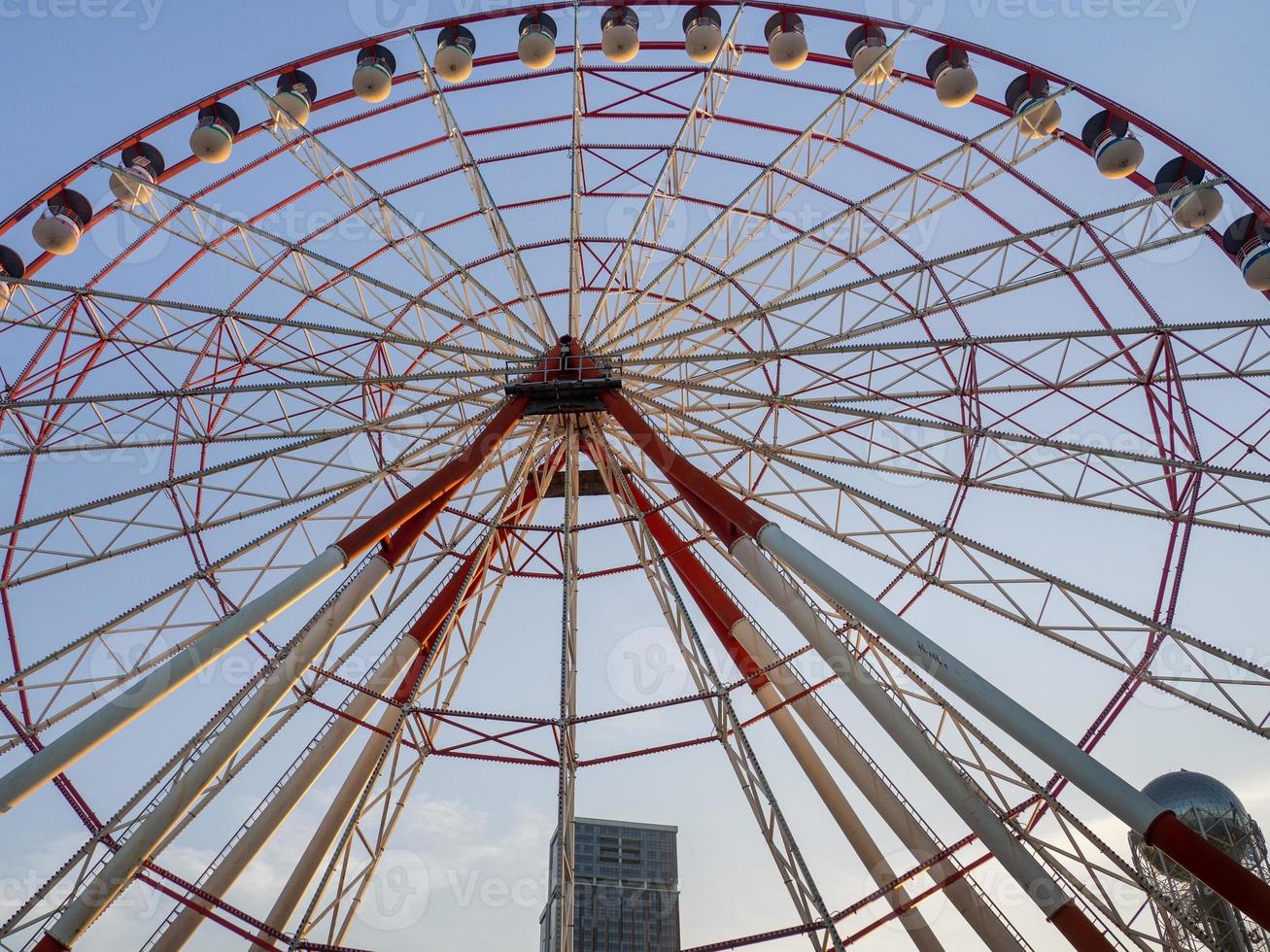 Ferris wheel against the sky. Amusement park by the sea. Rest zone. Round mechanism. Height lover photo
