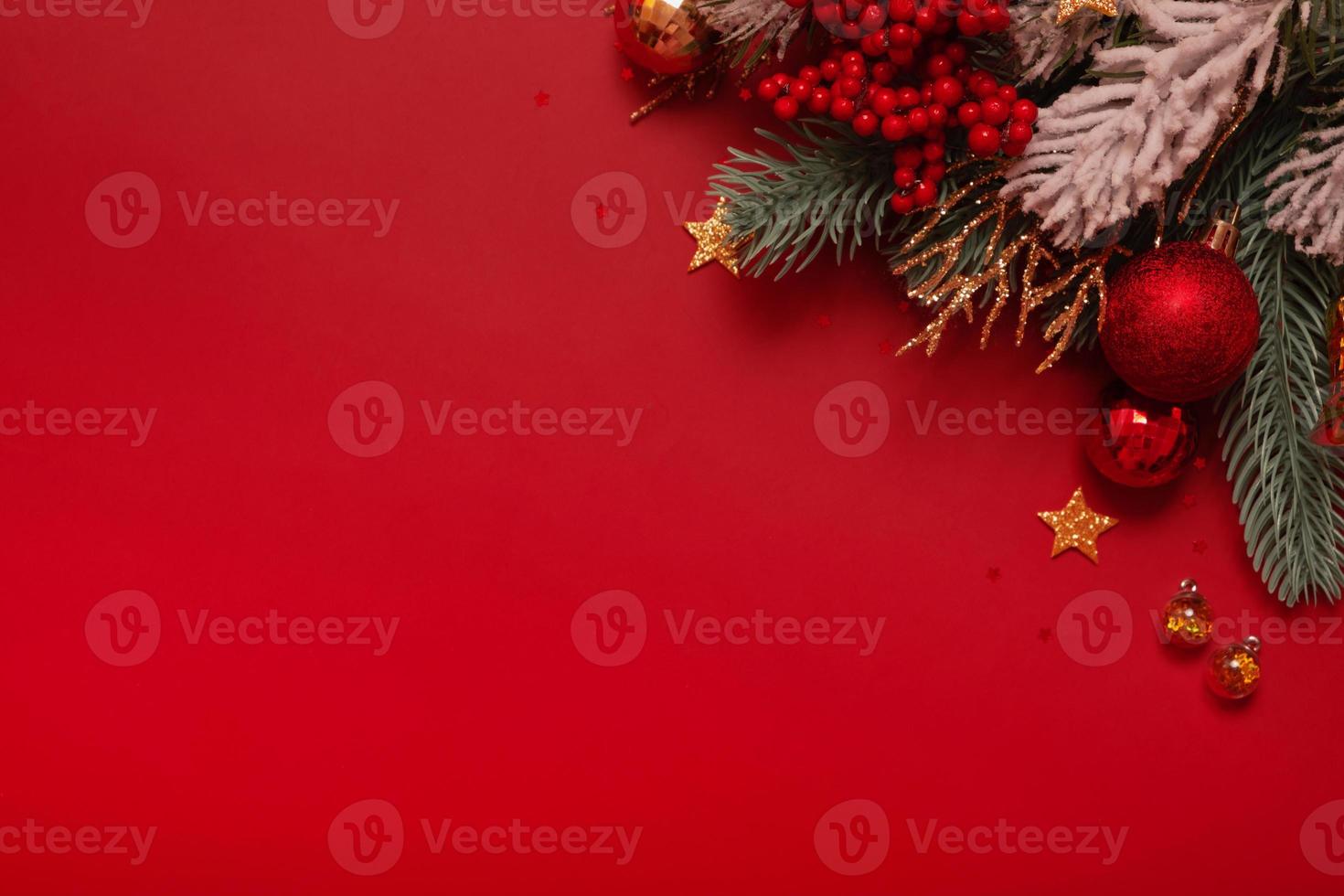 Christmas decoration and pine tree on red background with copy space. New Year greeting card. Flat lay photo