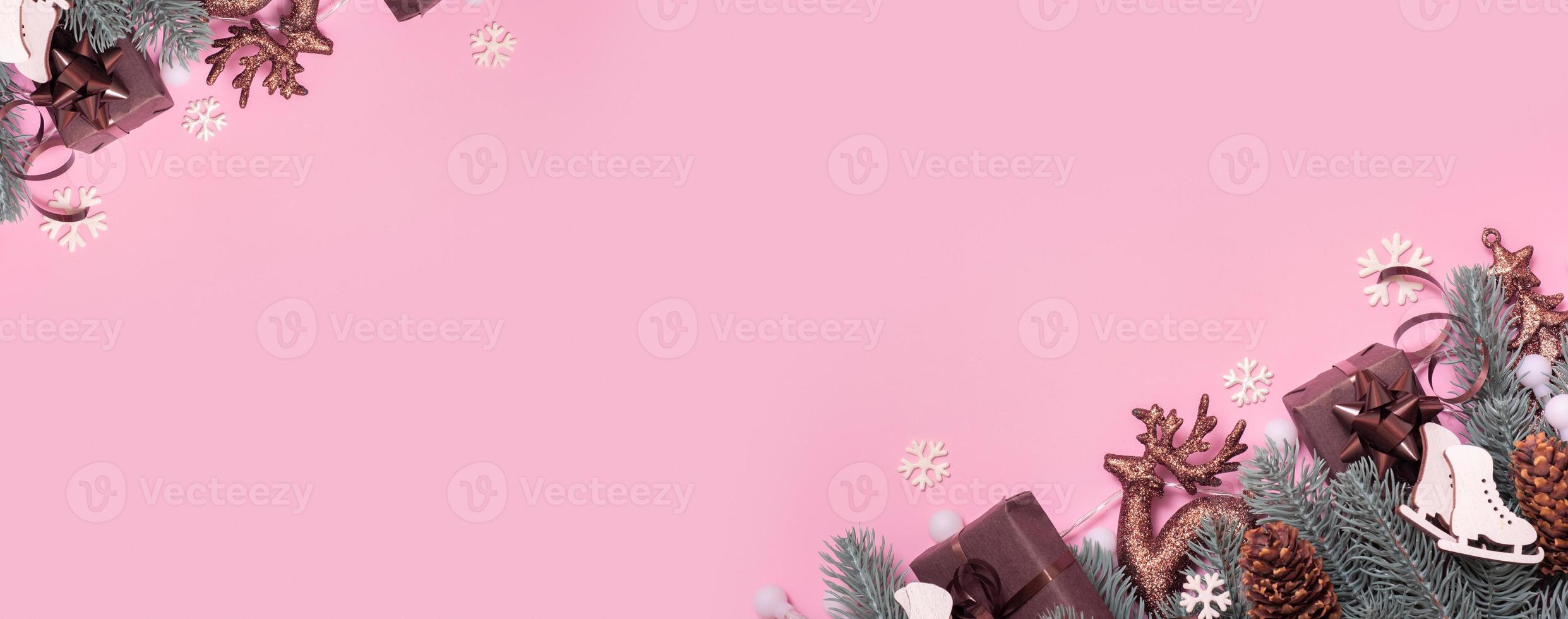 Pine trees branches with Cristmas New Year decoration top view, flat lay on pink background with copy space. Blank greeting card photo