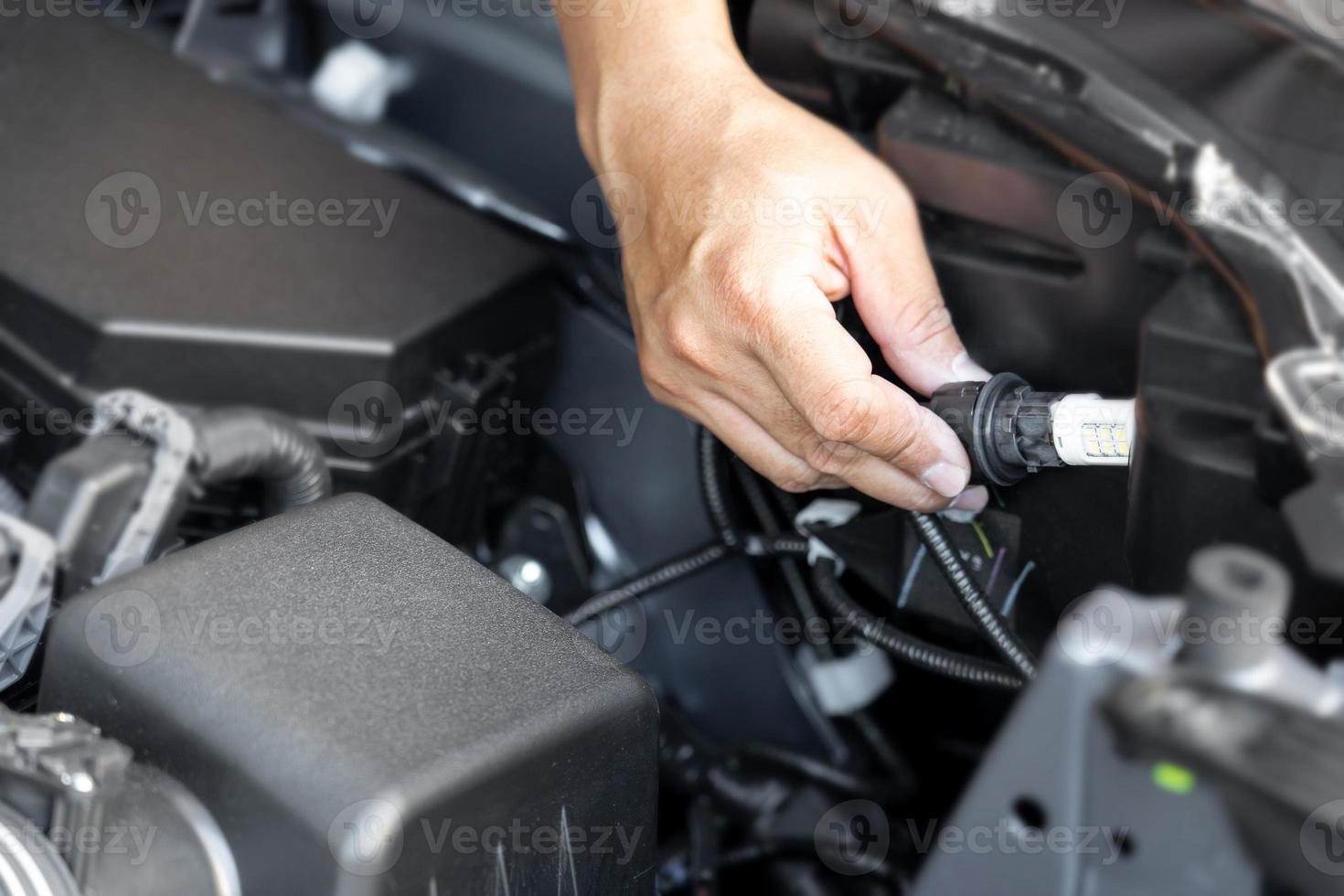 Close up hand a man LED bulbs are being inserted into the headlights of the car basic service concept do it yourself easily of car photo