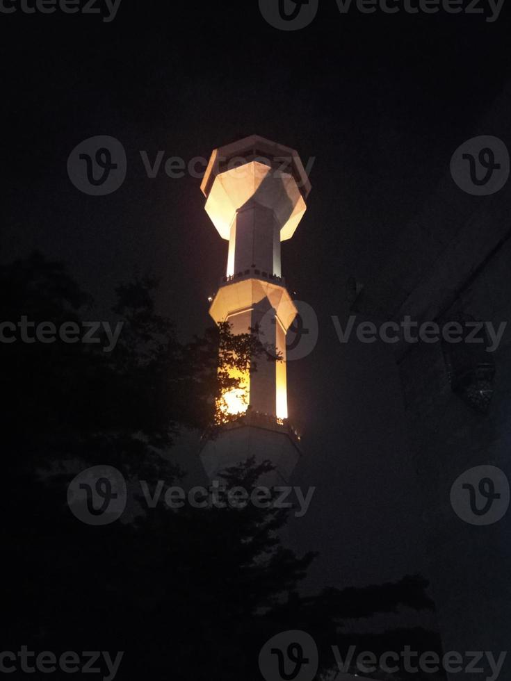 minaret of the mosque at night yellow light photo