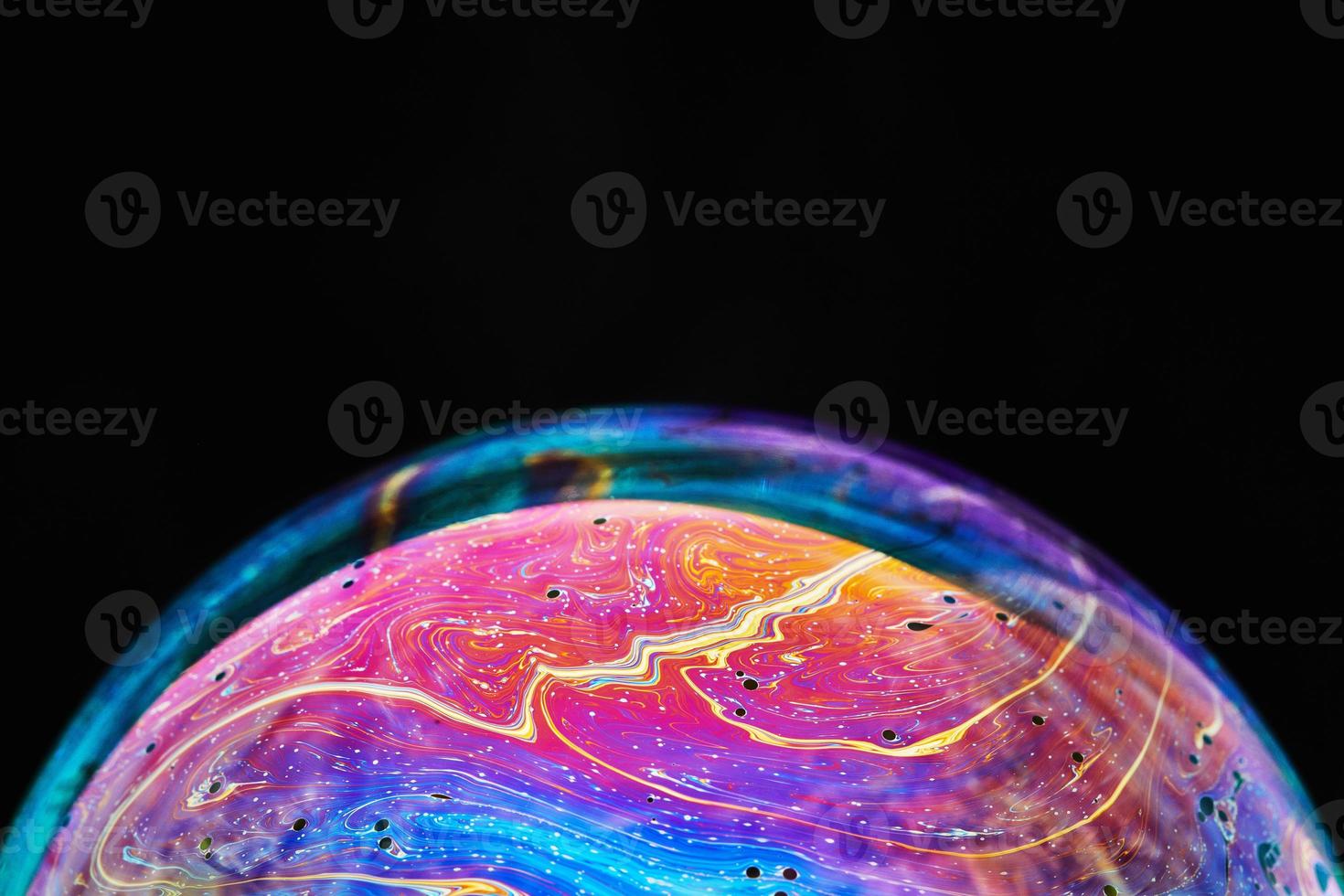 Virtual reality space with abstract multicolor psychedelic planet. Closeup Soap bubble like an alien planet on black background photo