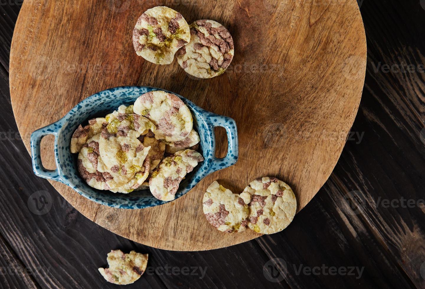 Puff chips with chickpeas, peas and beans in bowl on wooden background photo