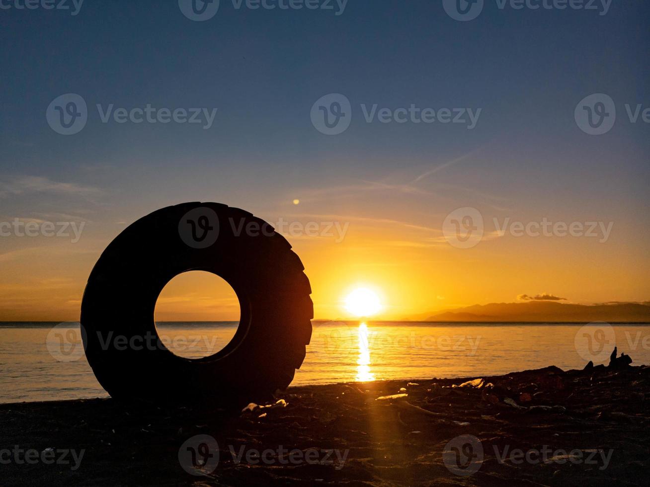 silhouette of objects on the beach with sunrise photo