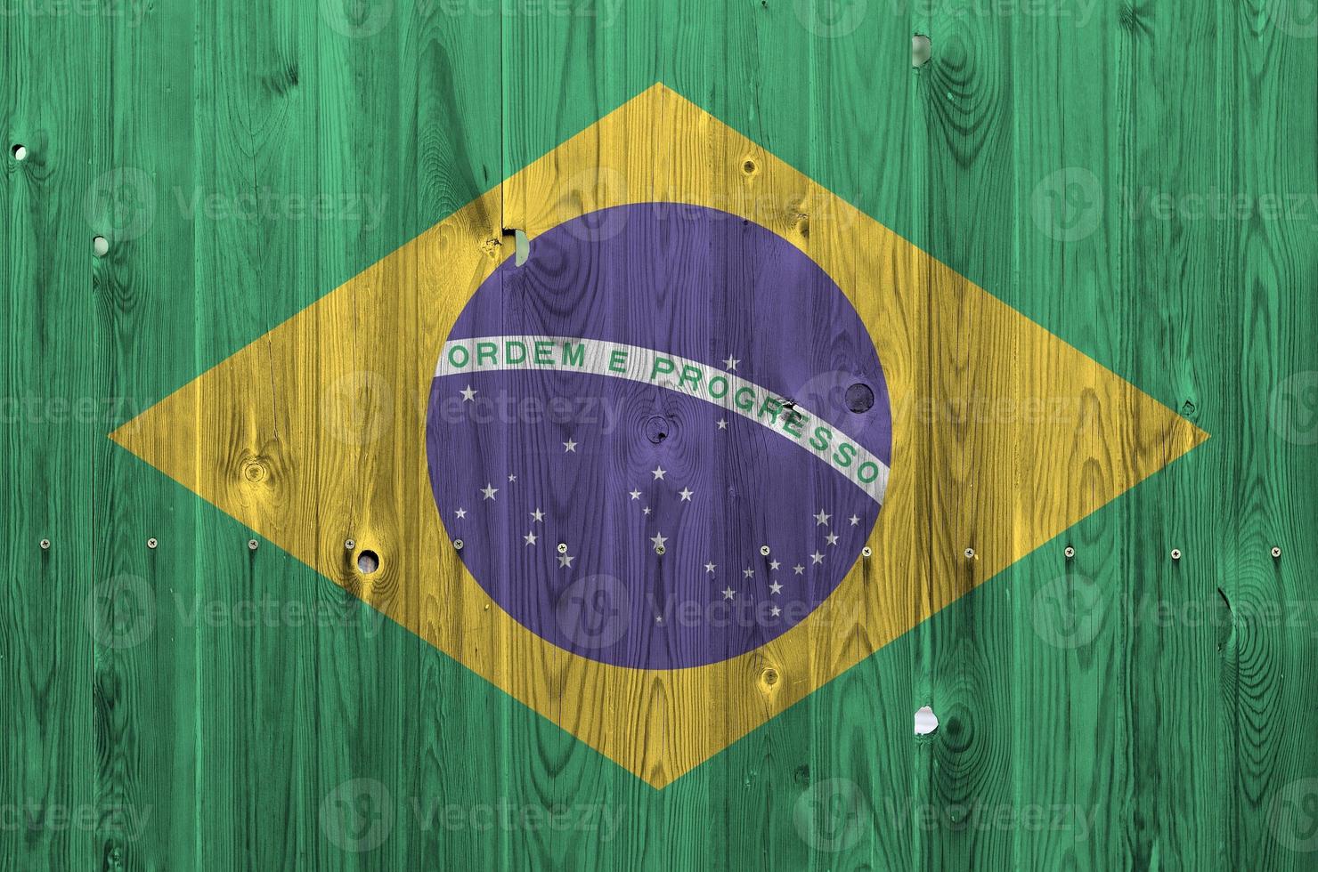 bandera de brasil representada en colores de pintura brillante en la pared de madera vieja. banner texturizado sobre fondo áspero foto