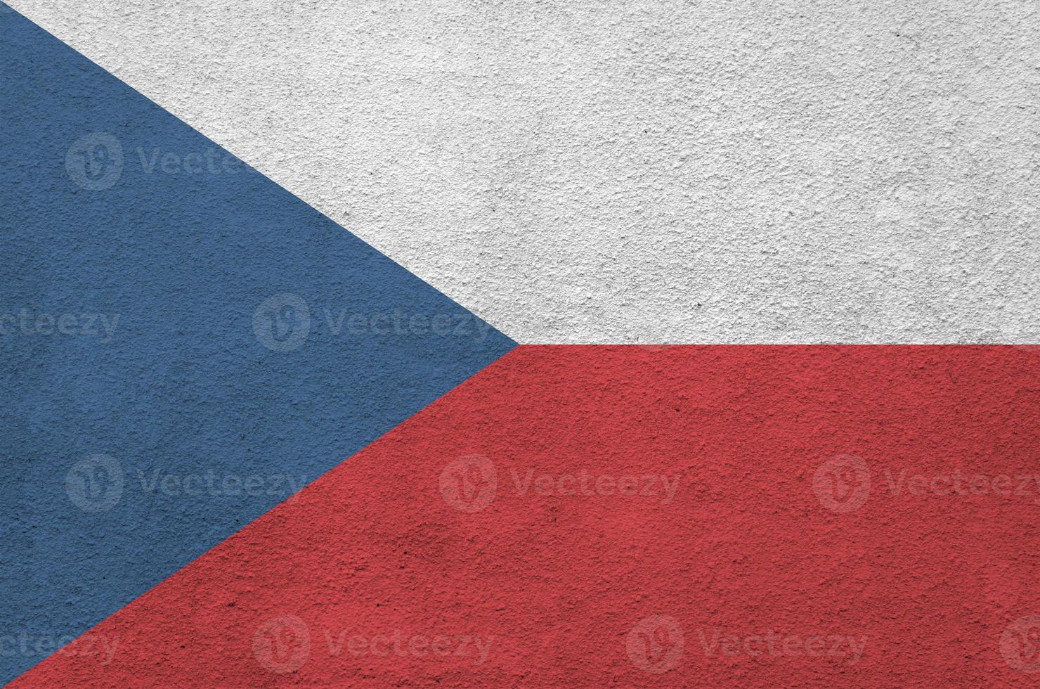 Czech flag depicted in bright paint colors on old relief plastering wall. Textured banner on rough background photo