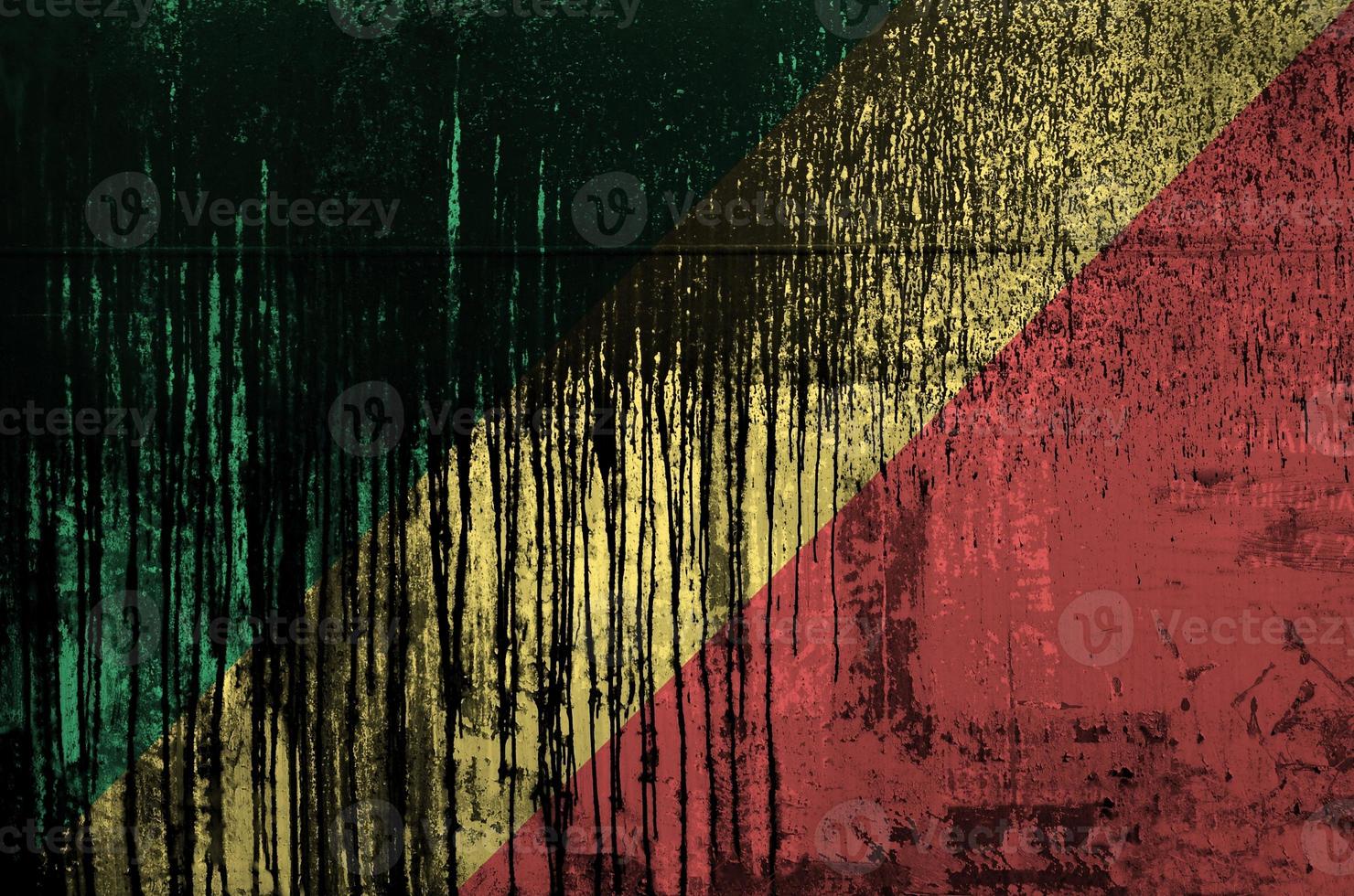 Congo flag depicted in paint colors on old and dirty oil barrel wall closeup. Textured banner on rough background photo