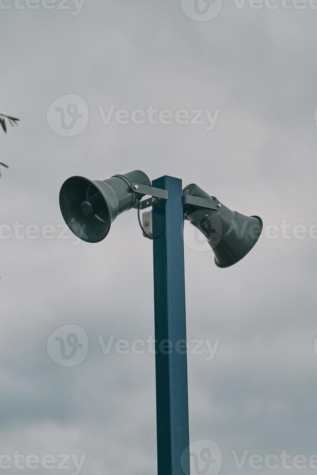 Tall column with two loudspeakers against cloudy sky. photo