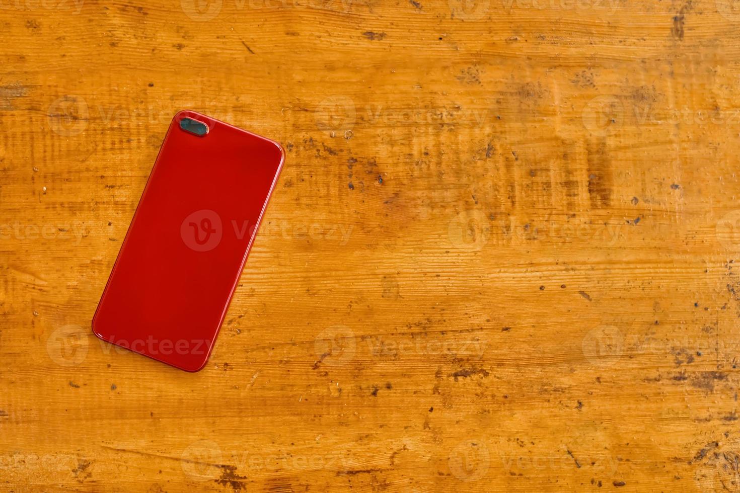 Flat lay of mobile phone on wooden table. photo