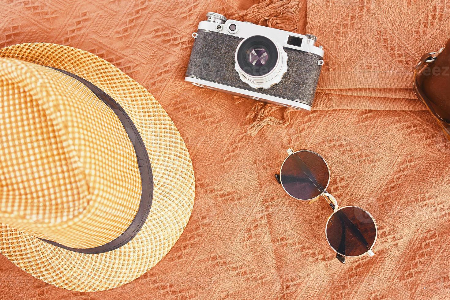 Hat, camera, glasses on the carpet. photo