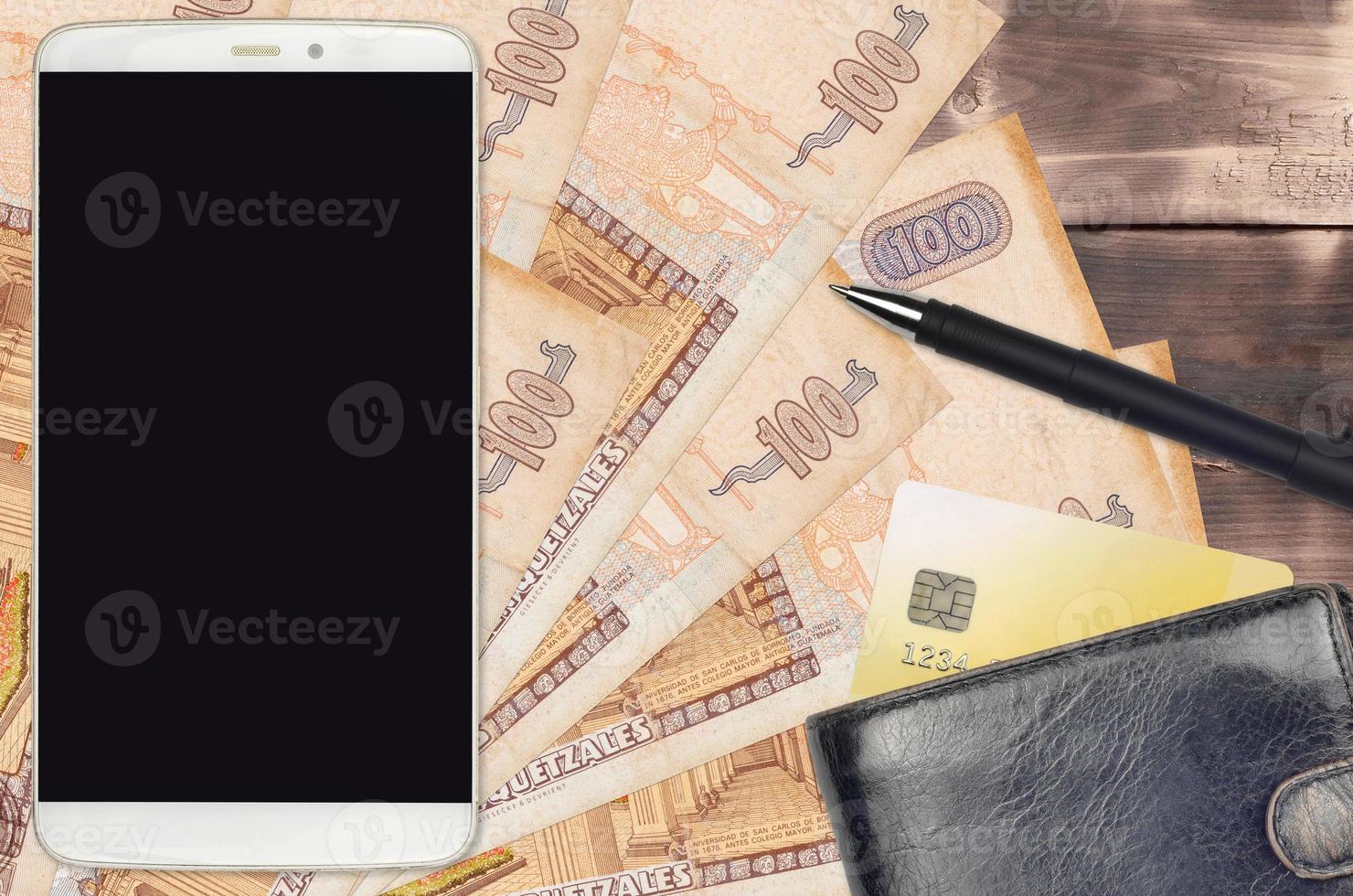 100 Guatemalan quetzales bills and smartphone with purse and credit card. E-payments or e-commerce concept. Online shopping and business with portable devices photo