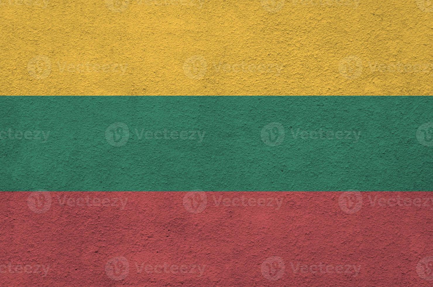 Lithuania flag depicted in bright paint colors on old relief plastering wall. Textured banner on rough background photo
