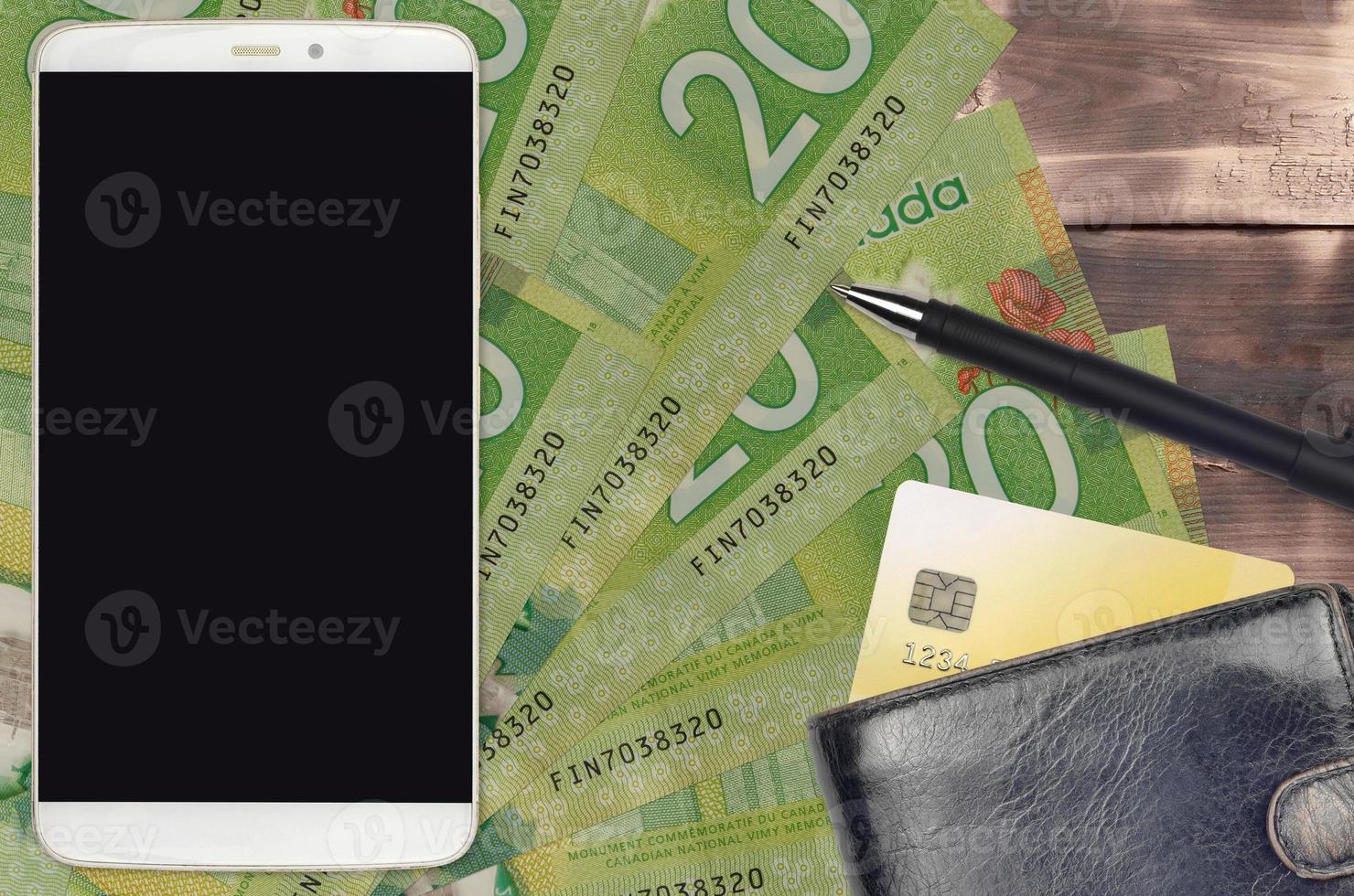 20 Canadian dollars bills and smartphone with purse and credit card. E-payments or e-commerce concept. Online shopping and business with portable devices photo