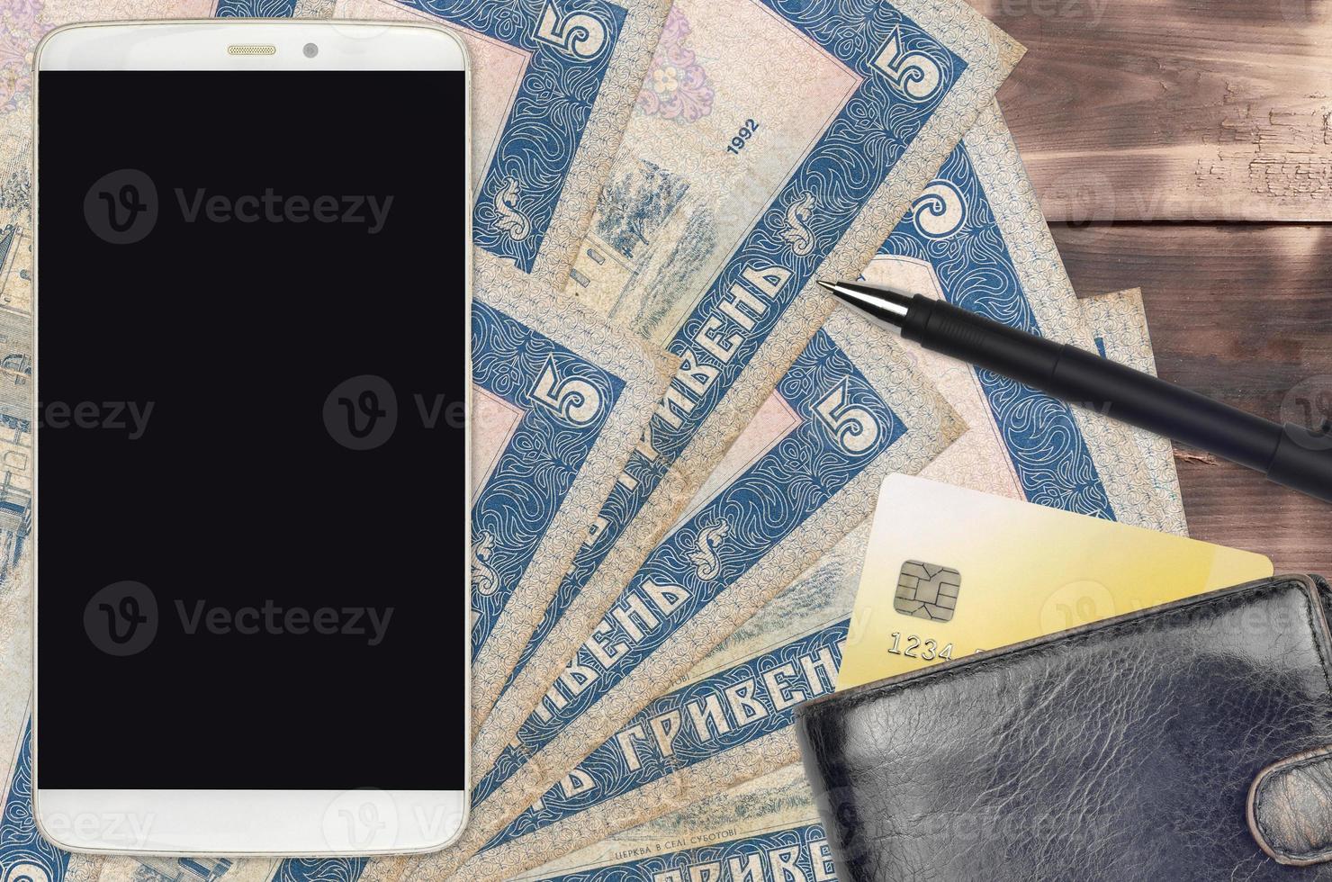 5 Ukrainian hryvnias bills and smartphone with purse and credit card. E-payments or e-commerce concept. Online shopping and business with portable devices photo