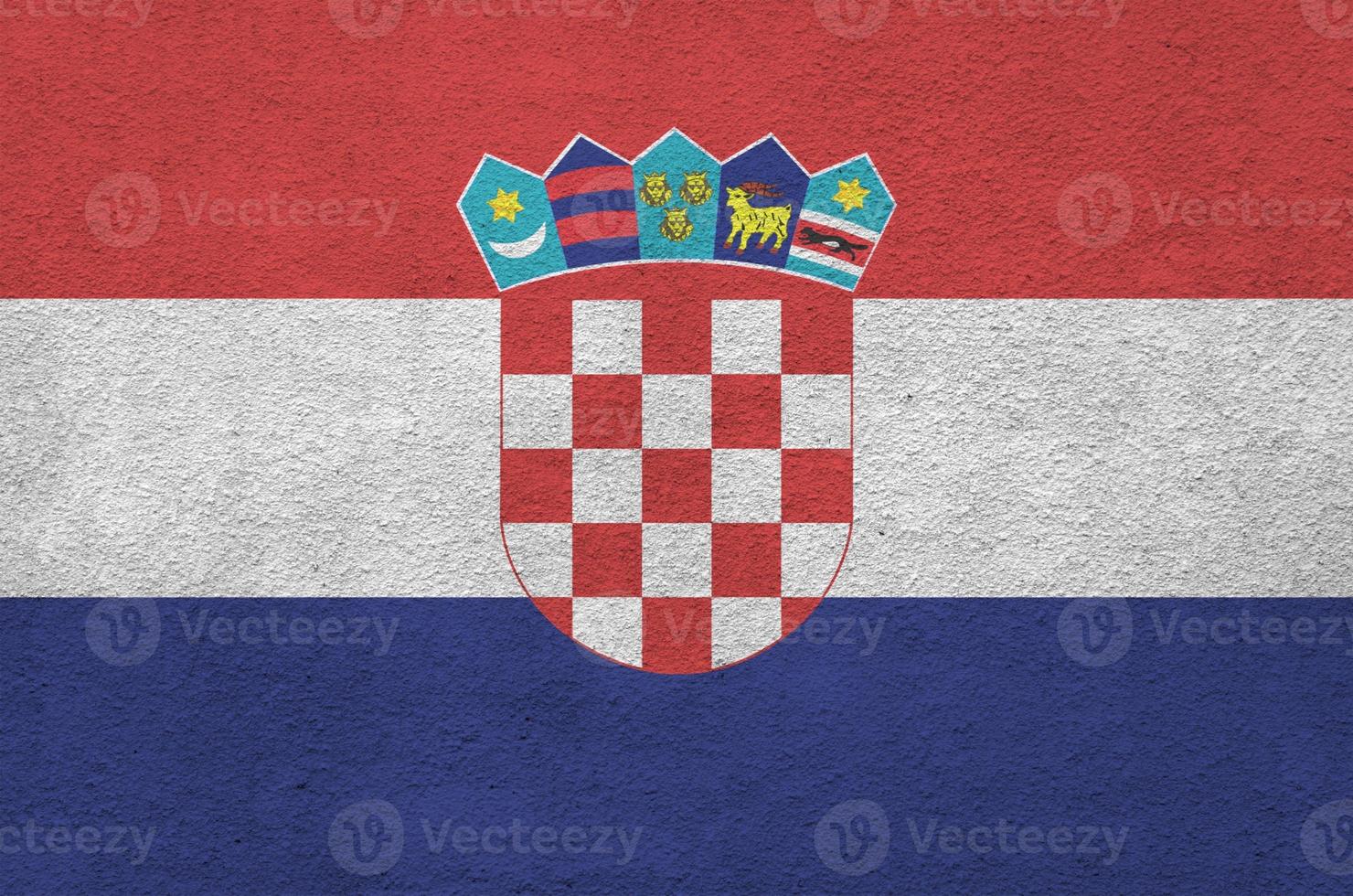 Croatia flag depicted in bright paint colors on old relief plastering wall. Textured banner on rough background photo