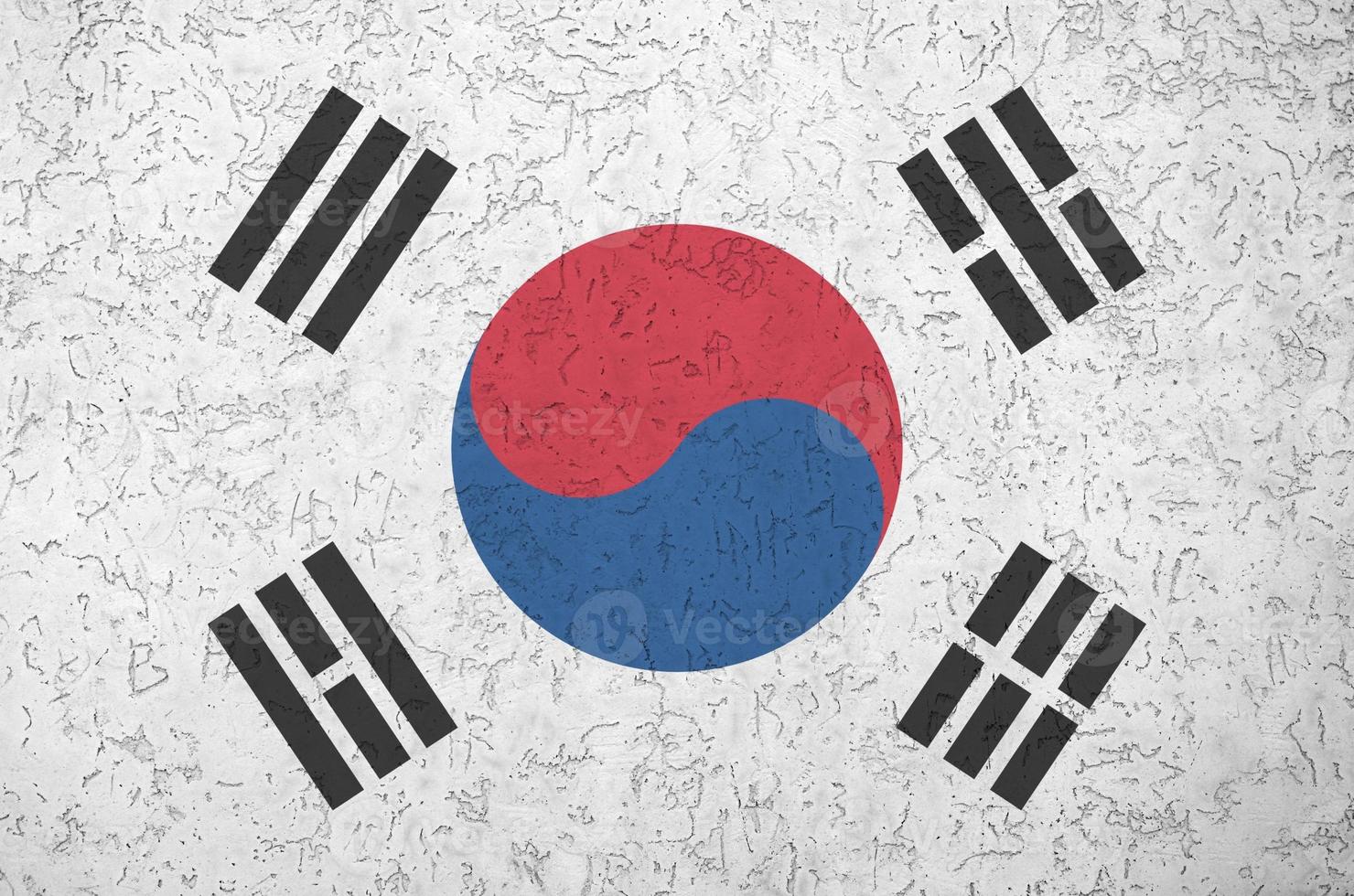 South Korea flag depicted in bright paint colors on old relief plastering wall. Textured banner on rough background photo