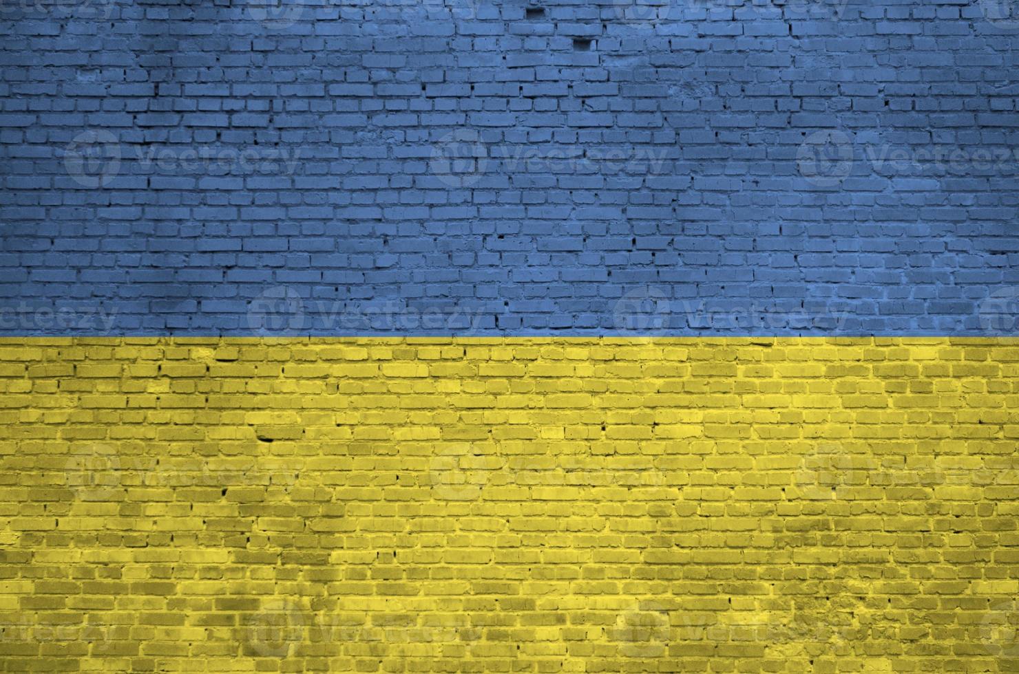 Ukraine flag depicted in paint colors on old brick wall. Textured banner on big brick wall masonry background photo