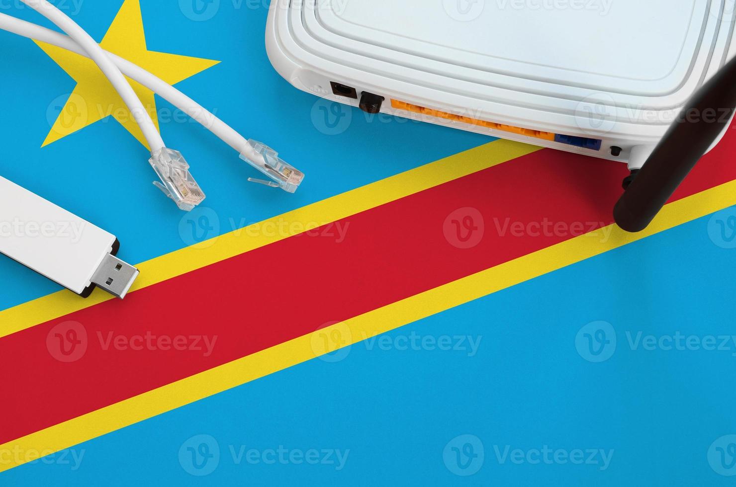 Democratic Republic of the Congo flag depicted on table with internet rj45 cable, wireless usb wifi adapter and router. Internet connection concept photo