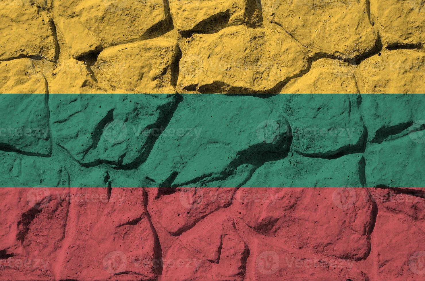 Lithuania flag depicted in paint colors on old stone wall closeup. Textured banner on rock wall background photo