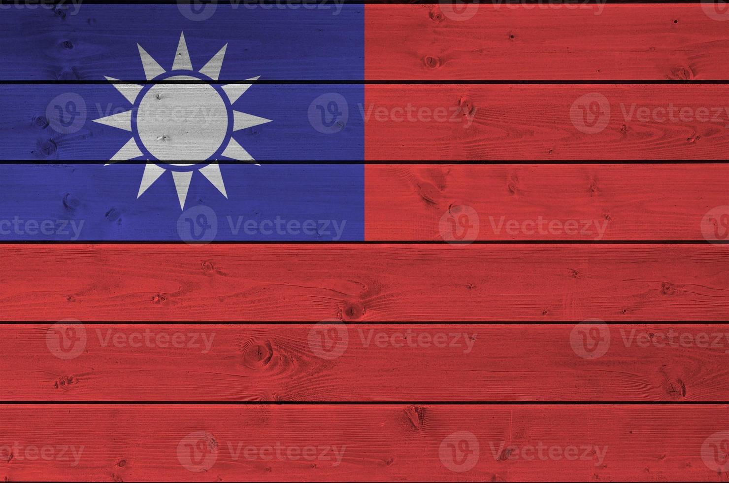 Taiwan flag depicted in bright paint colors on old wooden wall. Textured banner on rough background photo