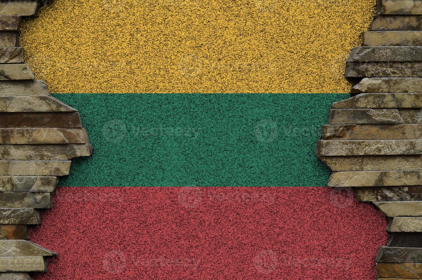 Lithuania flag depicted in paint colors on old stone wall closeup. Textured banner on rock wall background photo