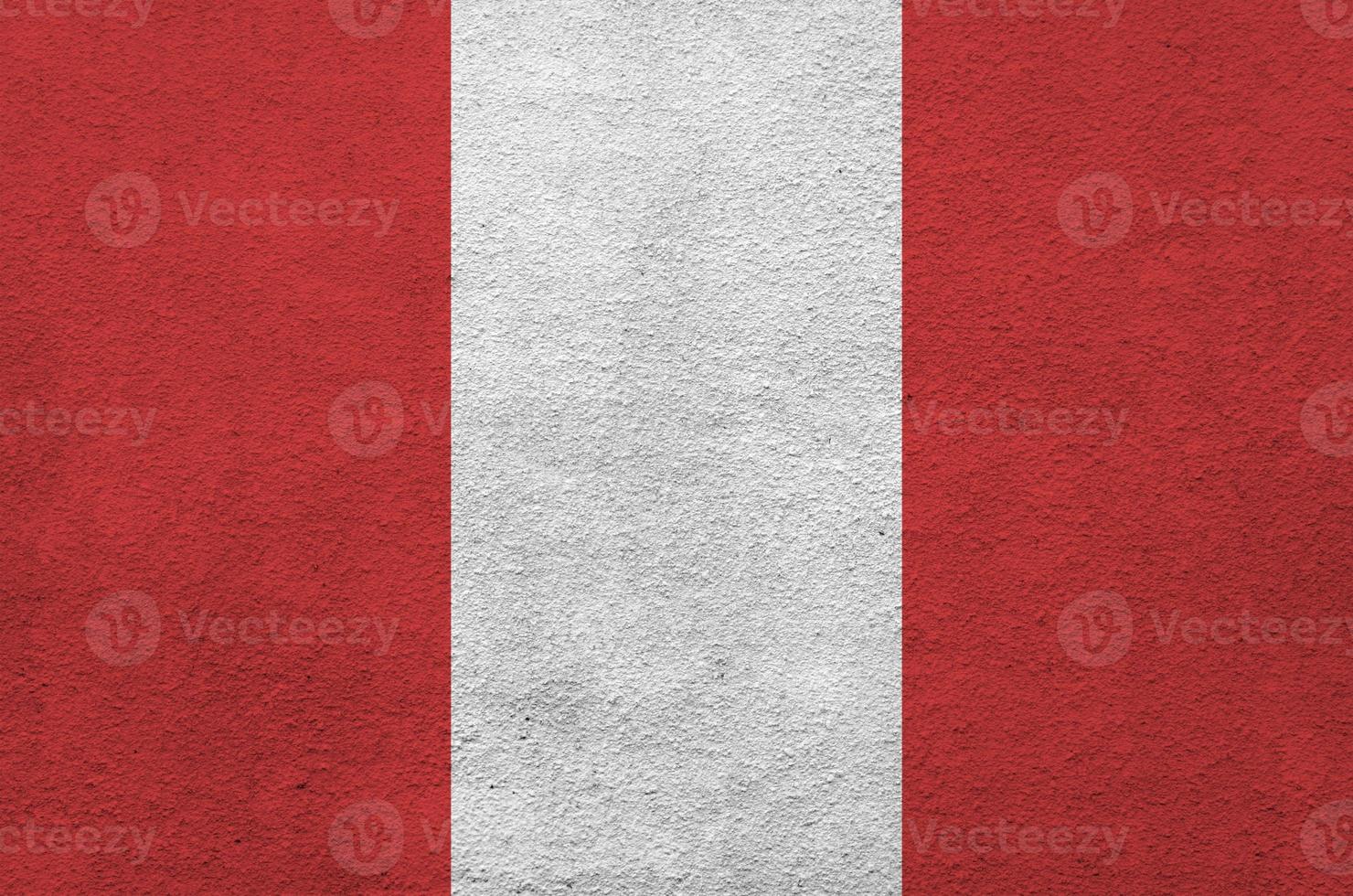 Peru flag depicted in bright paint colors on old relief plastering wall. Textured banner on rough background photo