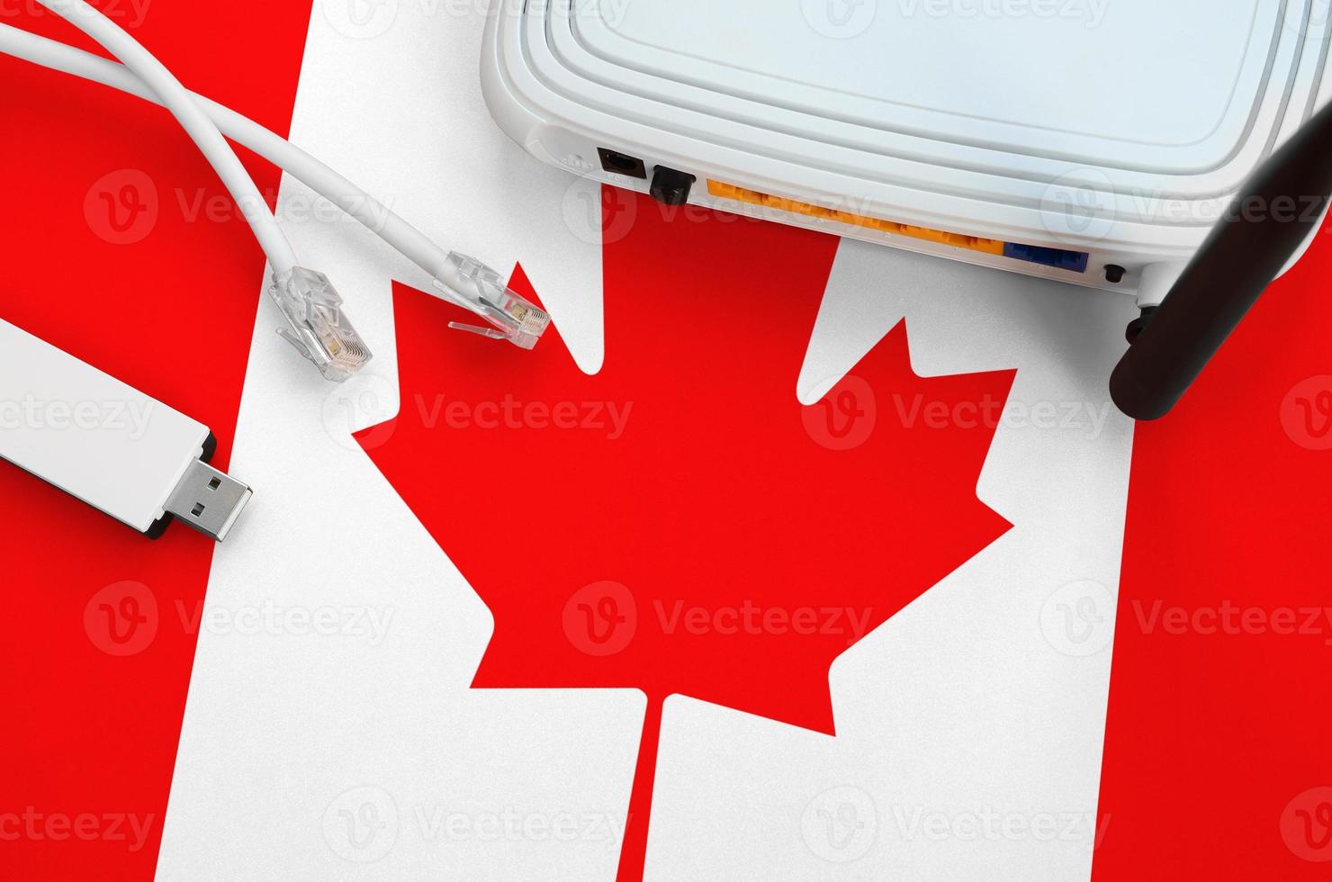 Canada flag depicted on table with internet rj45 cable, wireless usb wifi adapter and router. Internet connection concept photo