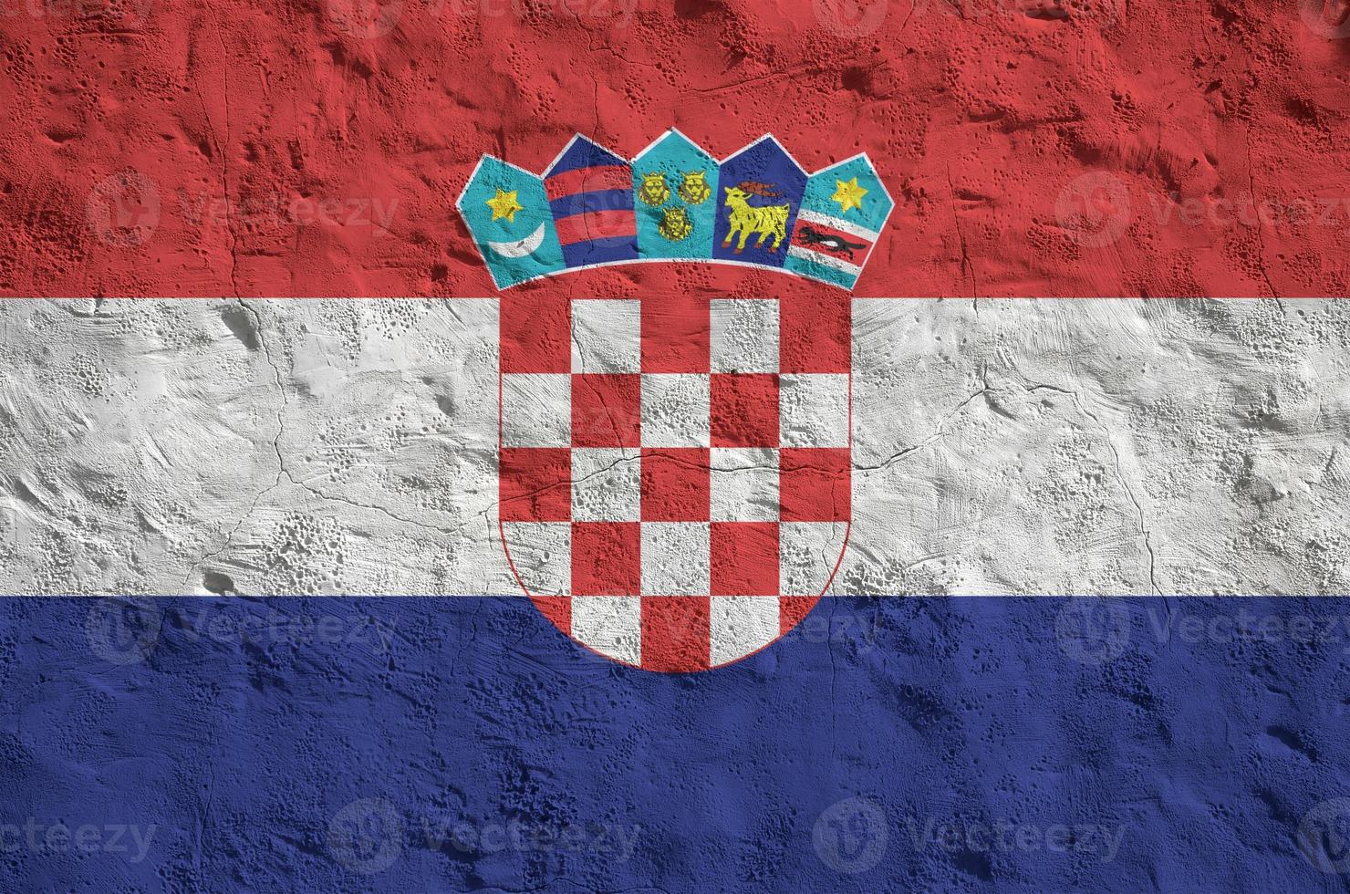Croatia flag depicted in bright paint colors on old relief plastering wall. Textured banner on rough background photo