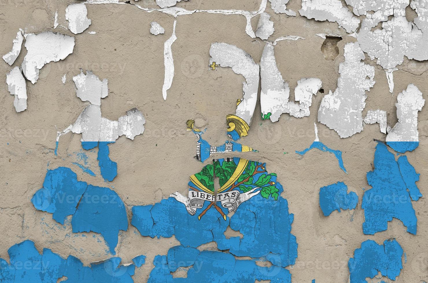 San Marino flag depicted in paint colors on old obsolete messy concrete wall closeup. Textured banner on rough background photo