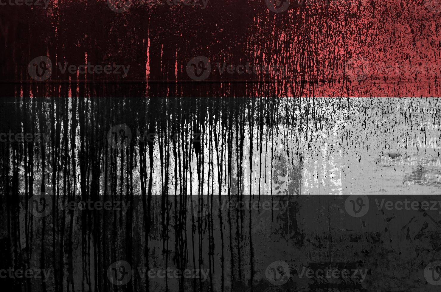 Yemen flag depicted in paint colors on old and dirty oil barrel wall closeup. Textured banner on rough background photo