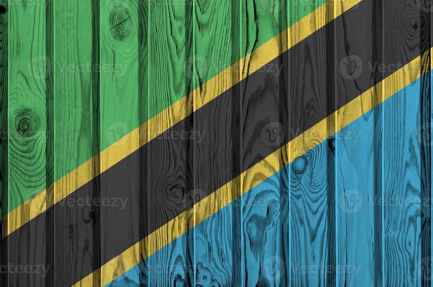 Tanzania flag depicted in bright paint colors on old wooden wall. Textured banner on rough background photo