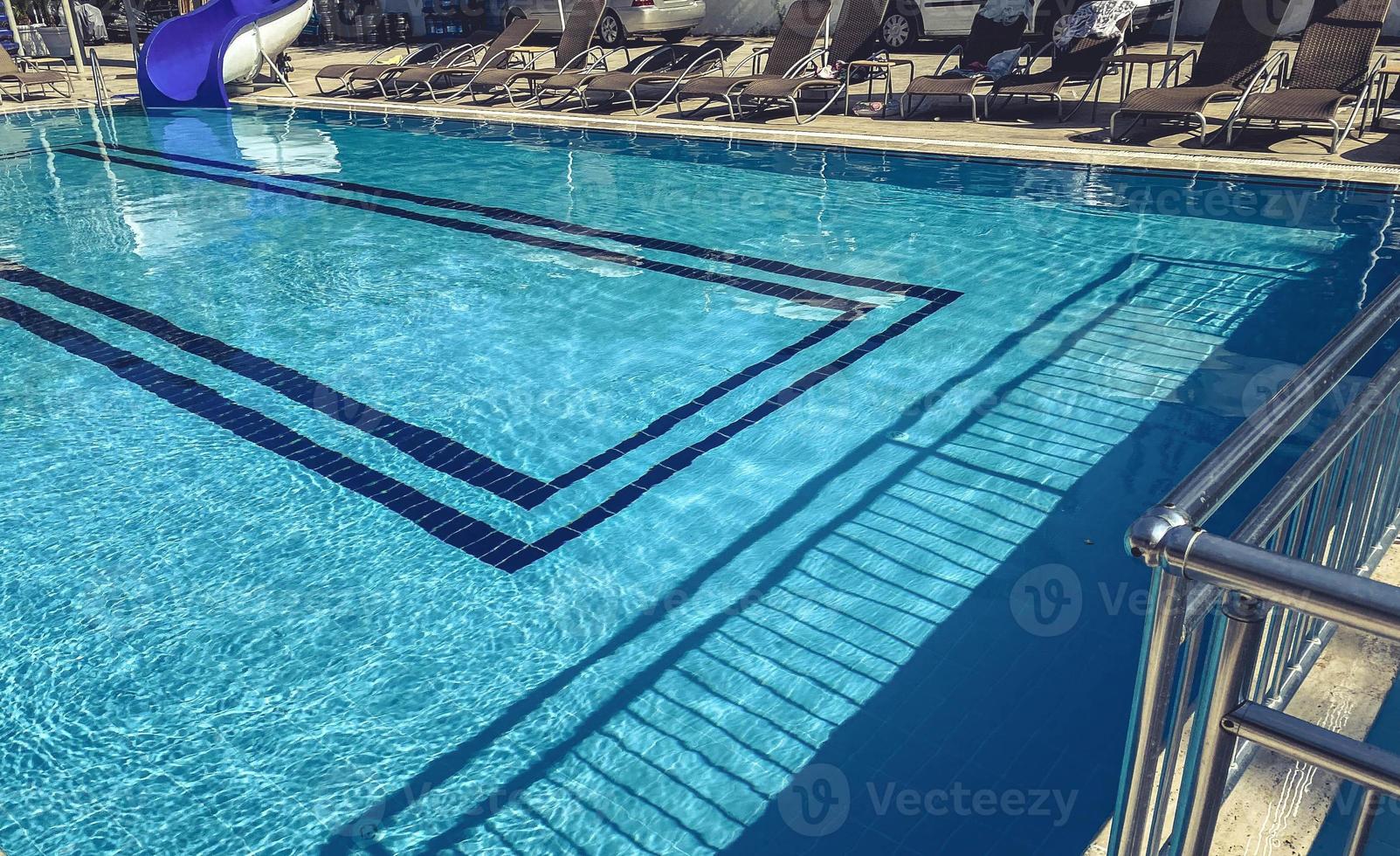 Swimming pool at the hotel next to the entrance. blue chlorinated water, at the bottom of the pool - tiles and a blue pattern photo