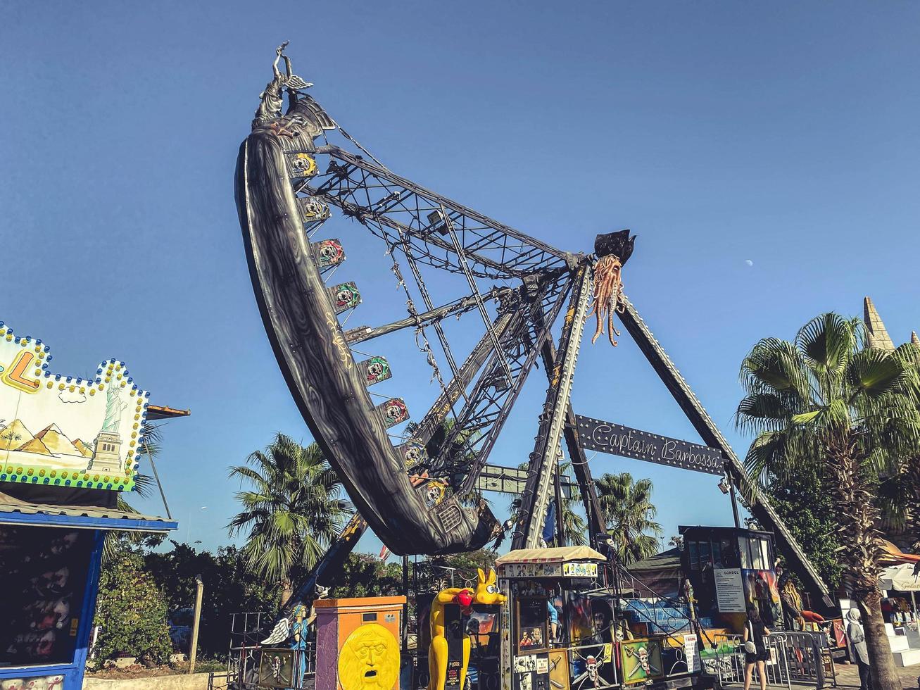 amusement park in tropical country. a high swing for tourists to ride up and down. extreme entertainment, mechanical swing for riding photo