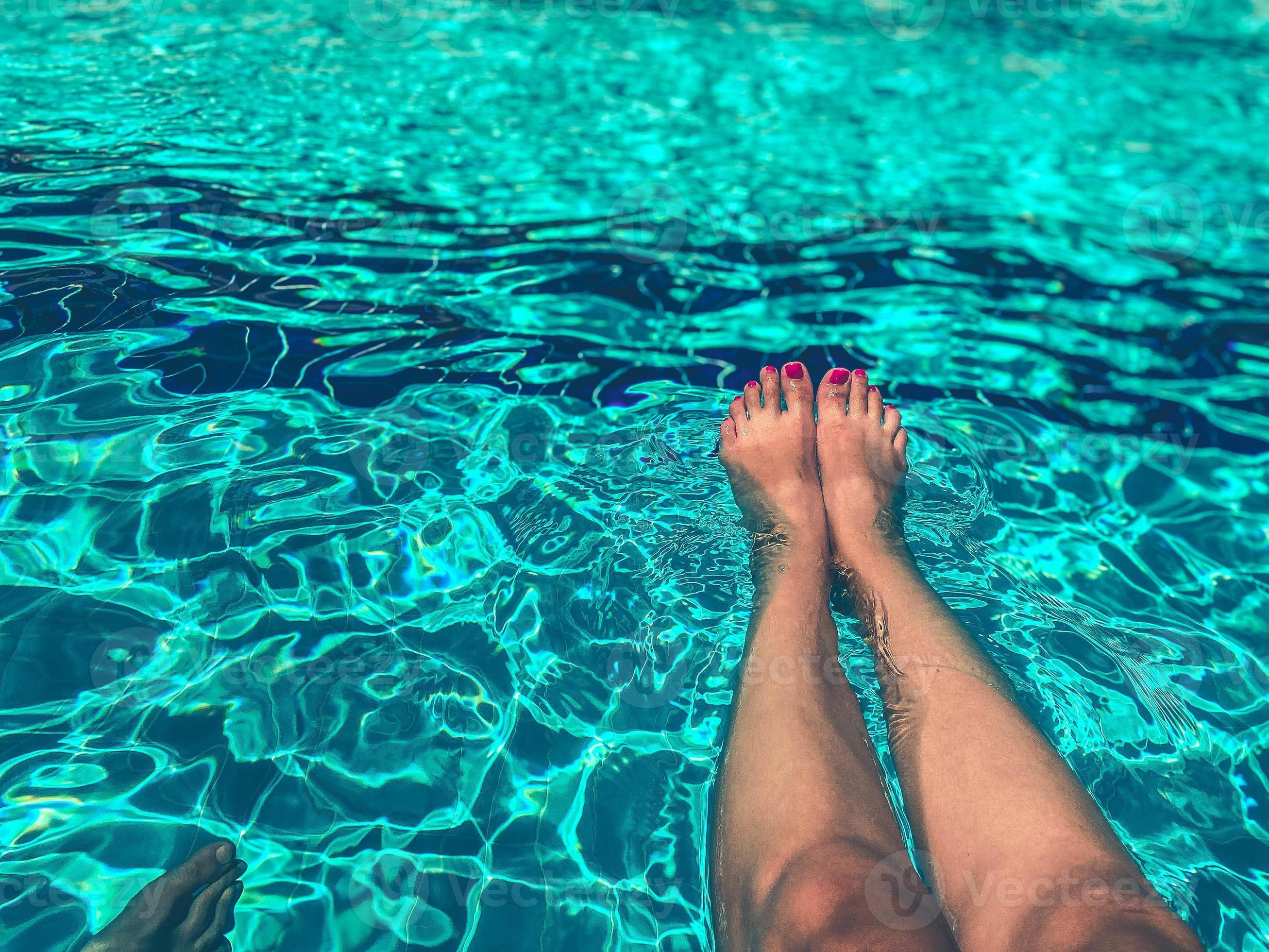 feet-of-a-girl-with-a-bright-pedicure-in-the-pool-swimming-in-the