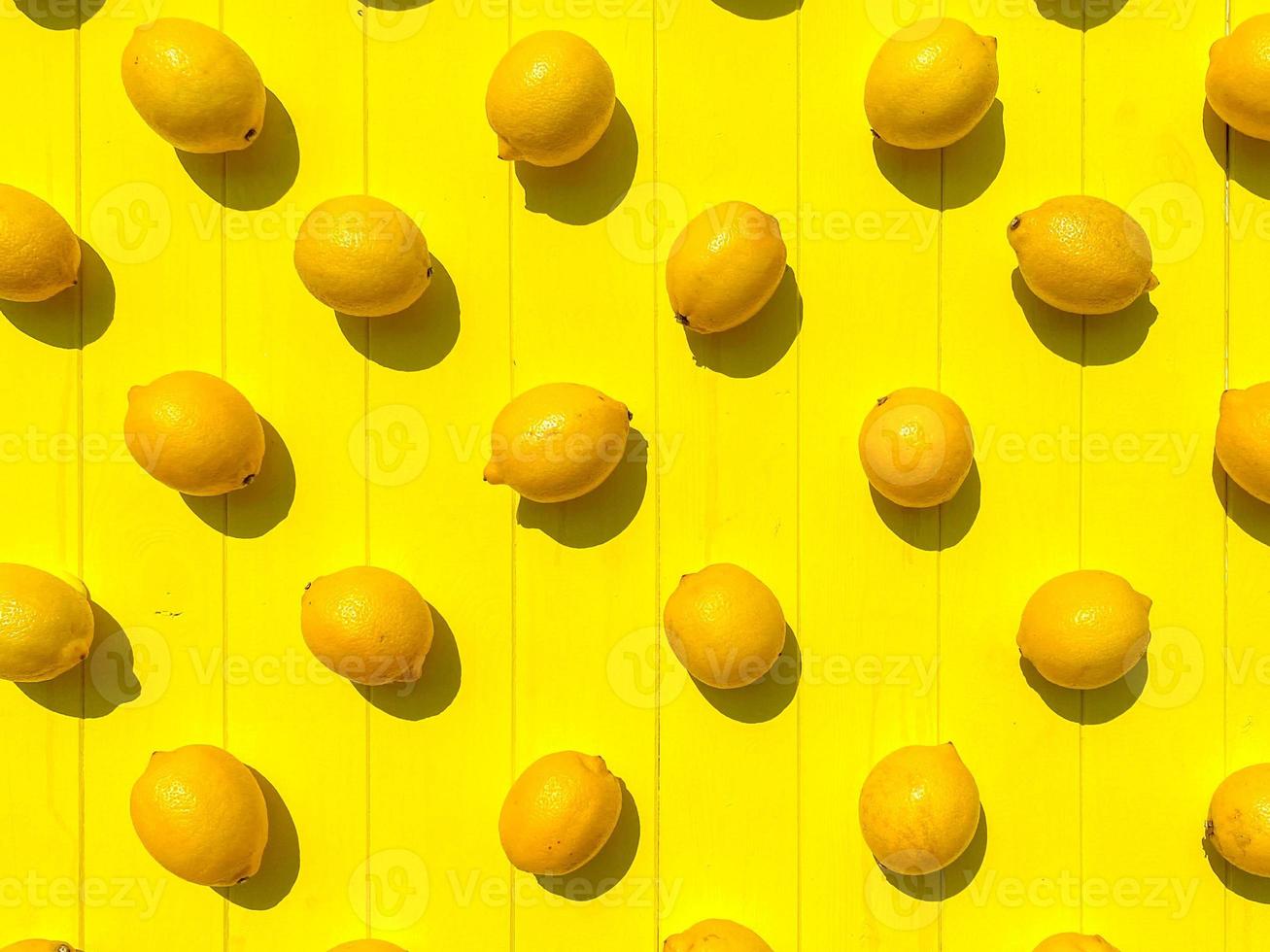 Flat lay composition of ripe whole and half lemons with leaves on light blue wooden background. Copy space, top view photo
