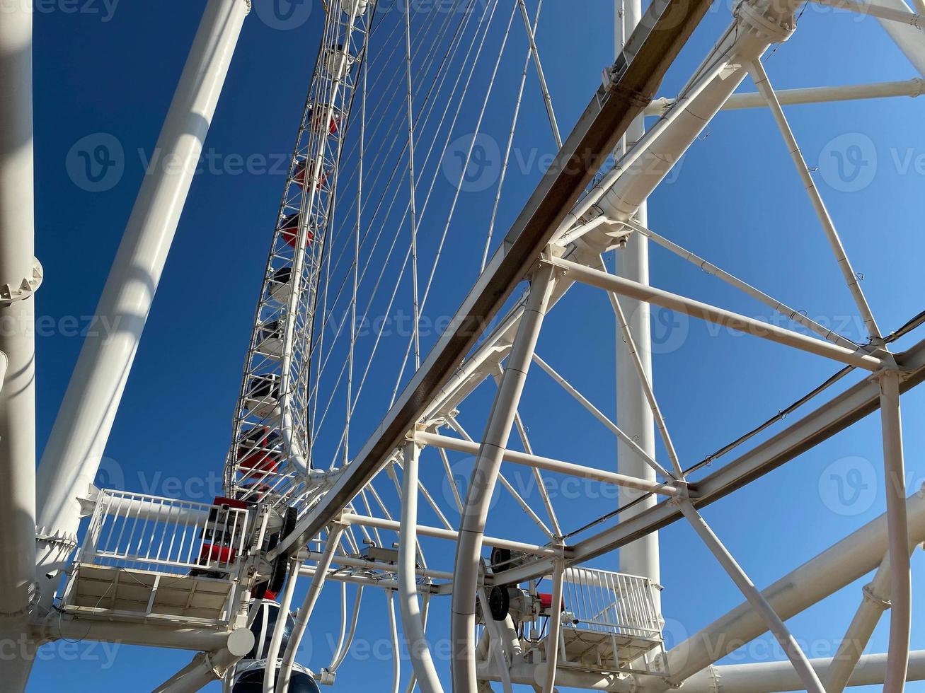 Photo From the bottom up a fragment of a modern Ferris wheel with booths against the sky