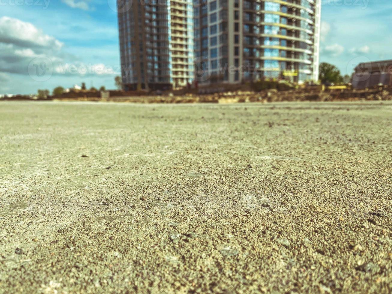 construction of a new microdistrict in the city center. construction of high concrete houses. beige sand and stone pavement photo