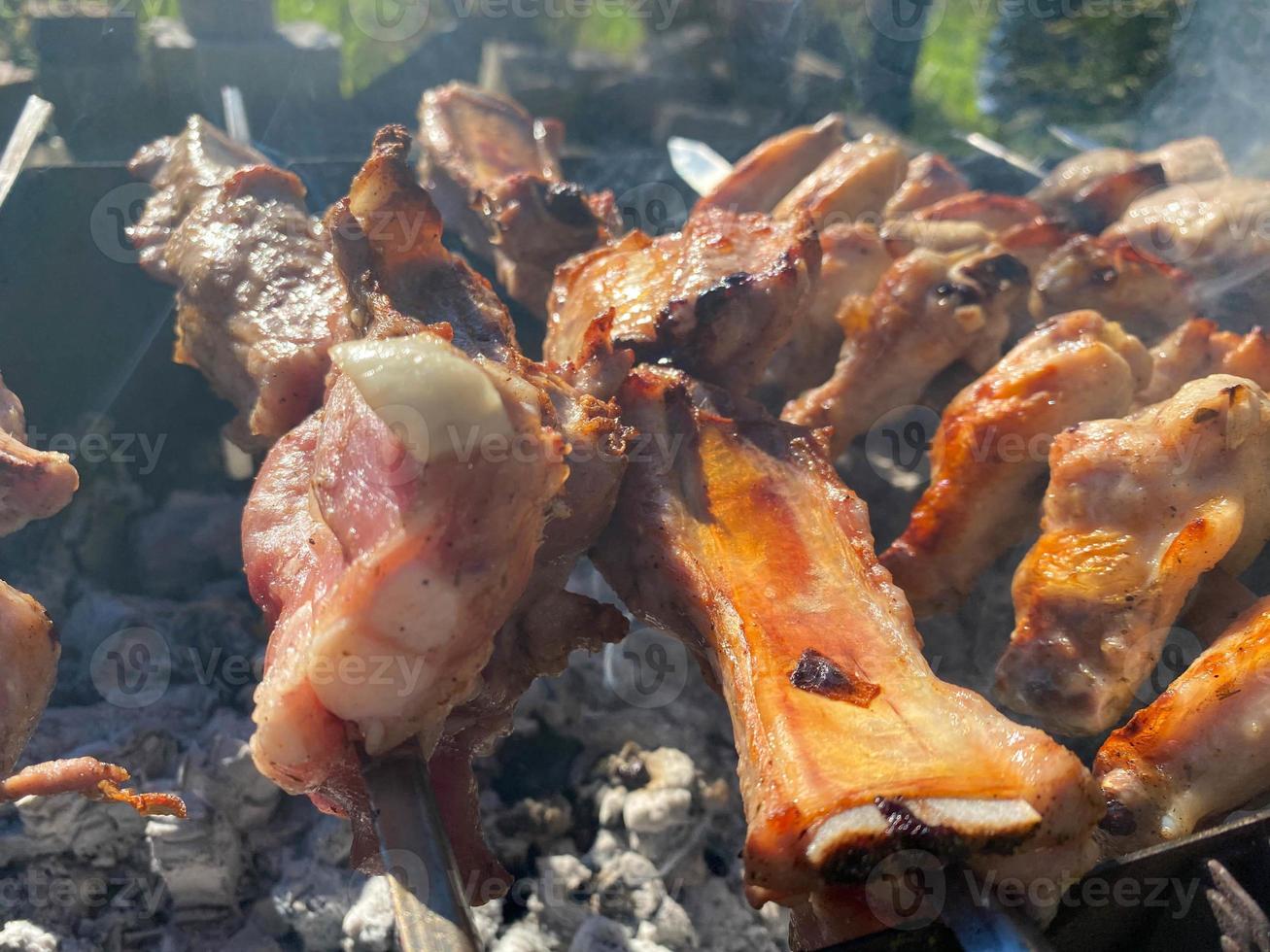 Grilling marinated shashlik preparing on a barbecue grill over charcoal.  Shashlik is a form of Shish kebab popular in Eastern Europe. Shashlyk (meaning  skewered meat) was originally made of lamb. Stock Photo